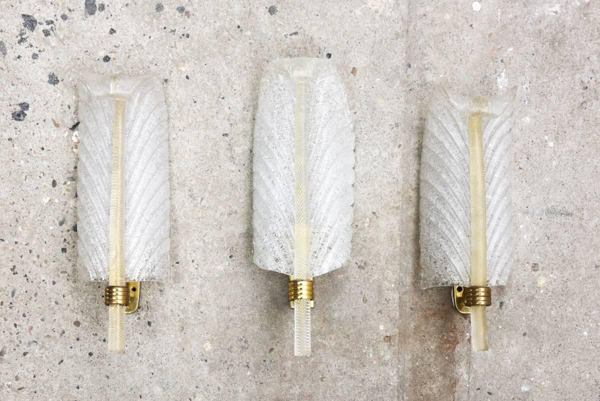 Three of Barovier e Toso feather shaped sconces. 

These single lights, in a feather design, Pulegoso glass and brass gilt mountings, designed by Barovier e Toso, 1950s, Murano, Italy.
Each sconce uses 1-40 watt max. candelabra base bulb.