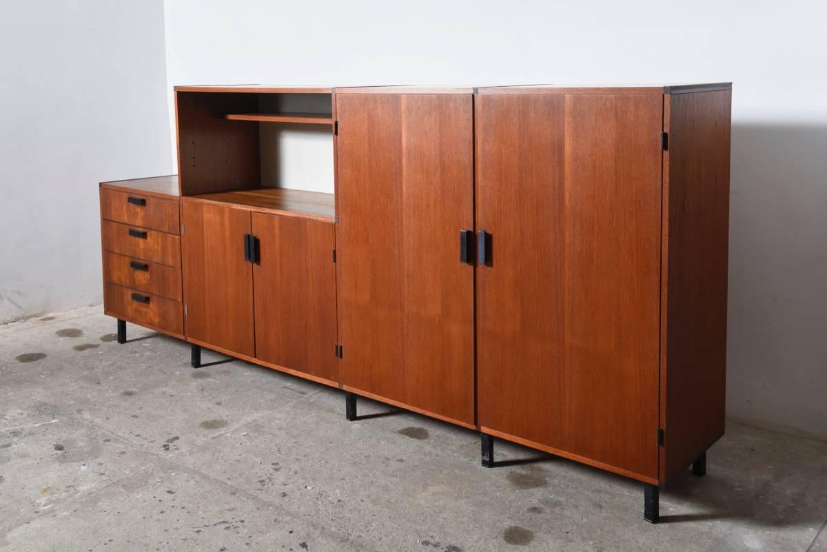 This Mid-Century Modern made to measure system sideboard was designed by Cees Braakman and produced by the Dutch company UMS Pastoe, 1950s. 
This sideboard is made from teak fineer and has four plywood anti-dust drawers with metal black lacquered