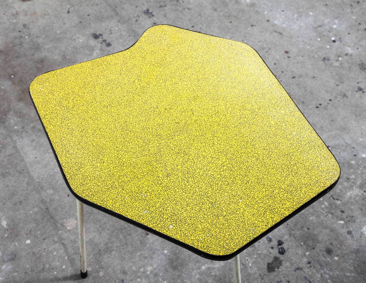 Very nice piece of Belgium Industrial Design. A rare side table designed for Tubax in 1950s.The table has a very nice decorated top leaf in 1950s formica in the form of a pallette in the color deep yellow with black drawing,framed with black plastic