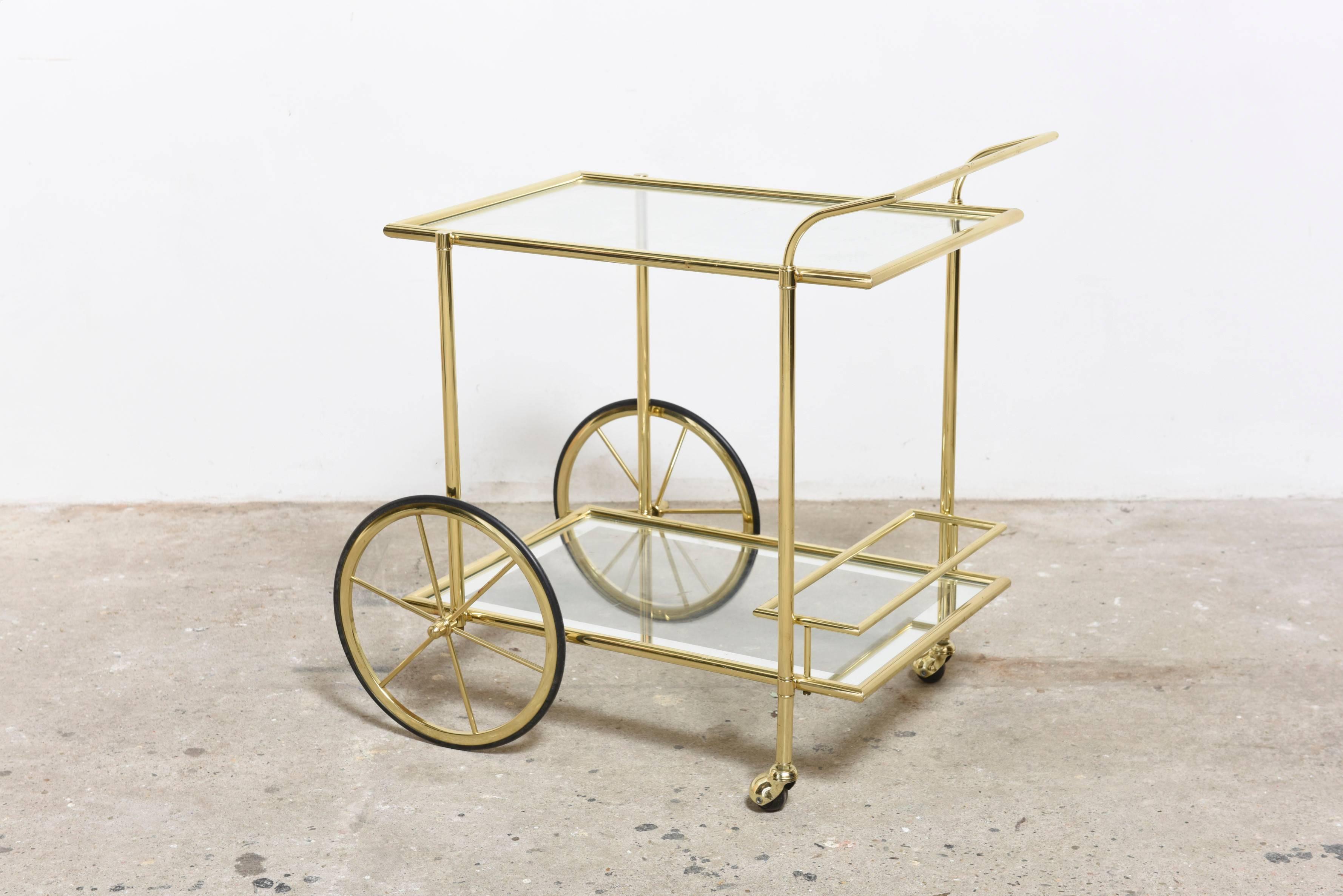  
Charming bar cart in brass with glass shelves with inlay silver and brass bottle holder on two larger wheels and casters.Simple and clean lines for this charming accessory.
In a Mint condition.