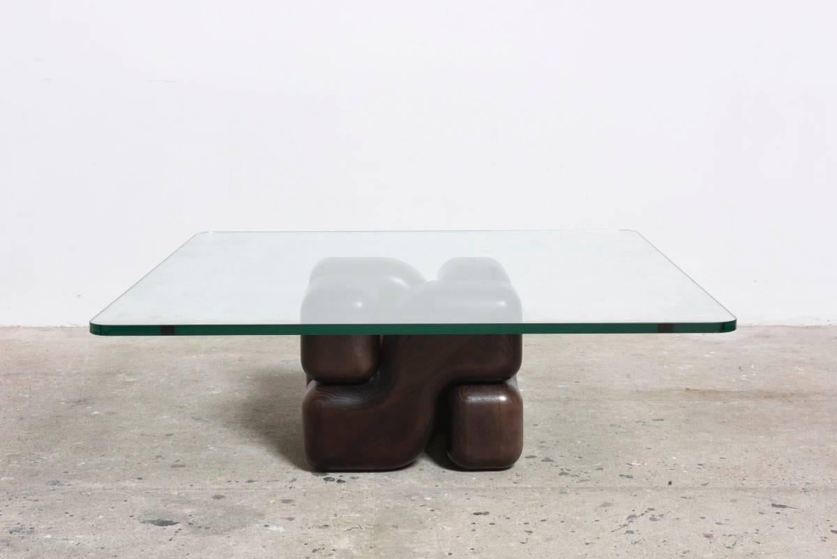 Coffee table base.

The coffee table consists of four parts in a "geometric" interlocking wooden dark walnut base with a thick glass top making it a work of art and a piece of fine furniture.