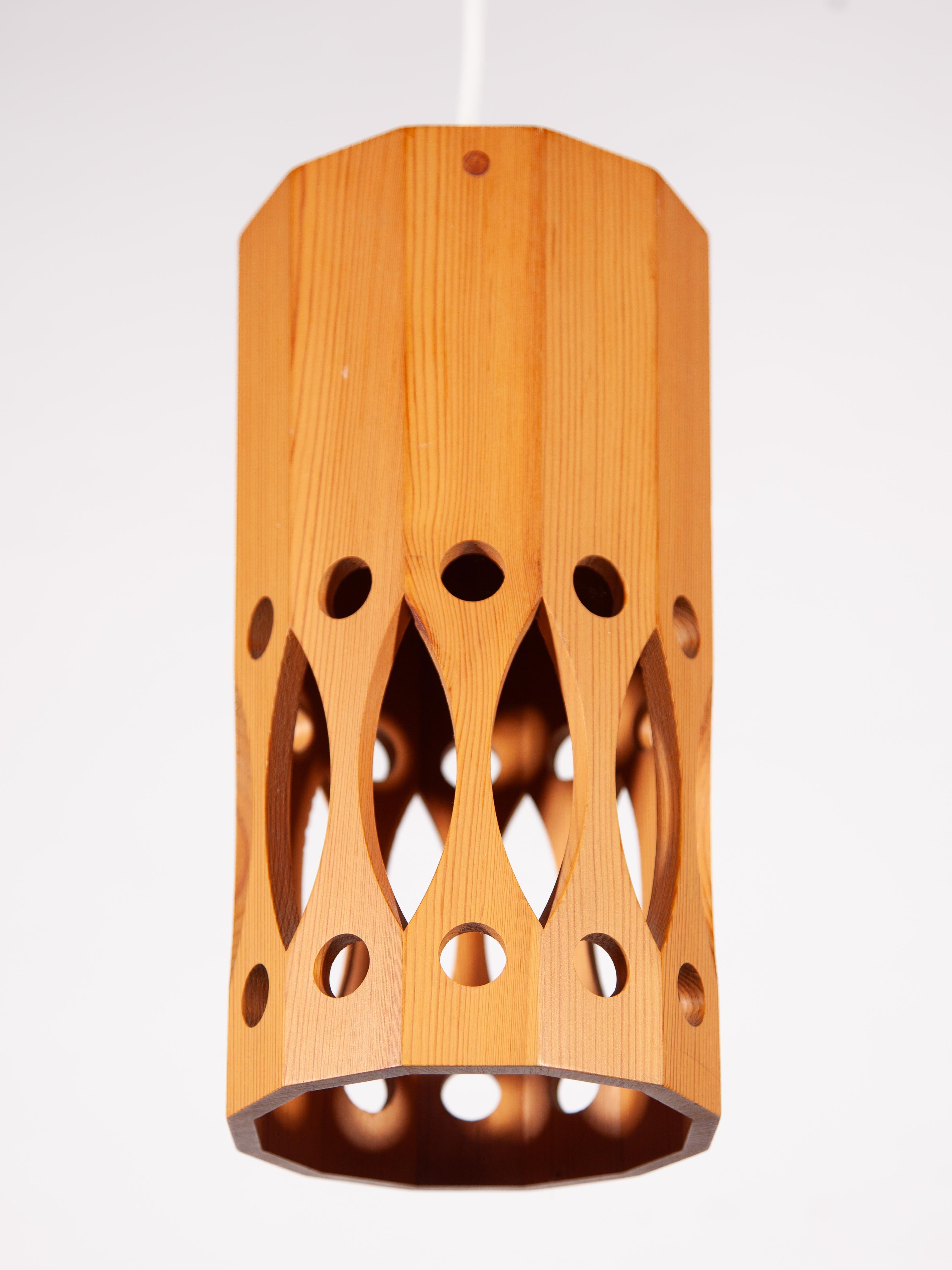 Un ciondolo in legno di pino naturale del Midcentury Modern, realizzato a mano e minimalista, disegnato da L.O. Nilsson per il produttore svedese Nordisk Present. Presenta un corpo cilindrico realizzato in pino massiccio con un motivo geometrico di