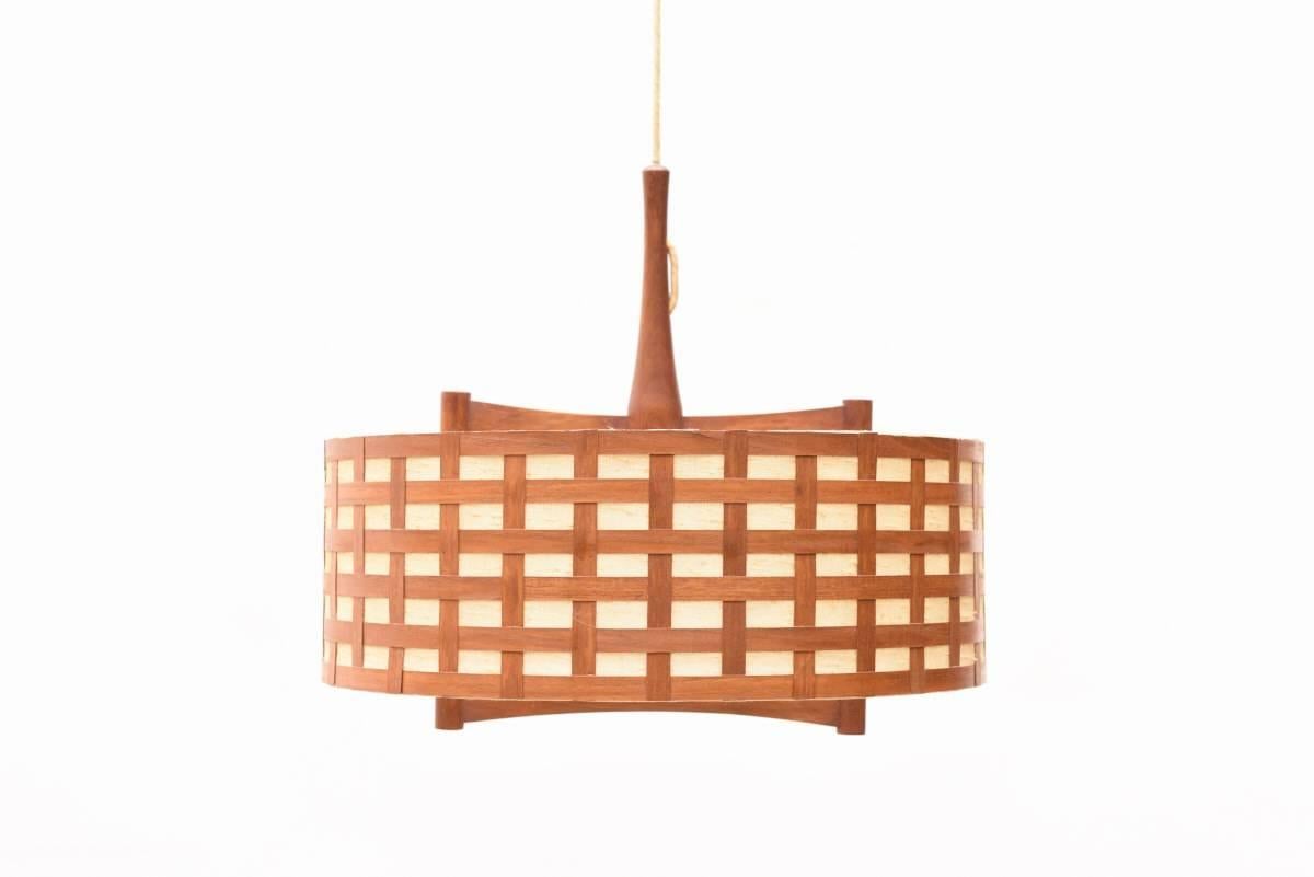 This rare teak and plywood wall lamp was designed by Hans-Agne Jakobsson for AB Ellyset Markaryd, made in Sweden in the 1960s.

This lamp gives a very beautiful light through the opaline glass shade and is adjustable in length.
In very good