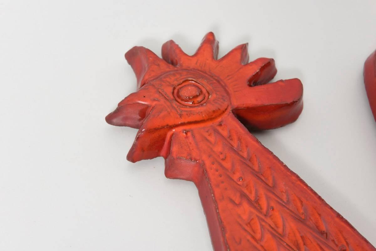 A beautiful stylized rooster, a red glazed ceramic sculpture to hang on the wall, stamped by Amphora Pottery, Belgium.