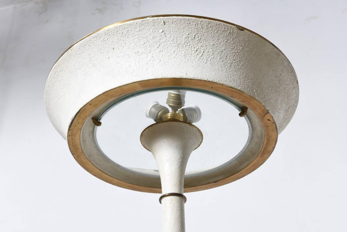 Raffinata lampada francese Art Deco in metallo laccato avorio con inserto in vetro sul paralume, anni '30. Condizioni originali, vernice avorio e oro con un sottile motivo di craquelure formatosi sulla superficie metallica del cappuccio, dell'asta e