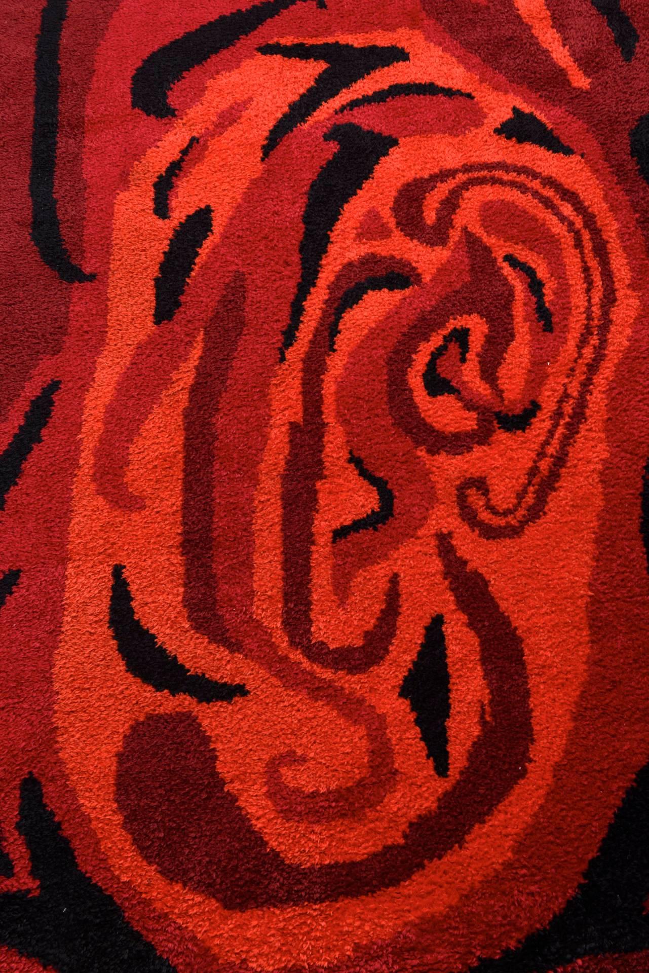 An unusual Scandinavian knotted carpet, characterized by a swirling pattern to appear in the middle an abstract designed mother and child figures in three tones of red, orange and black.
Patterns such as this one were clearly influenced by Op-Art