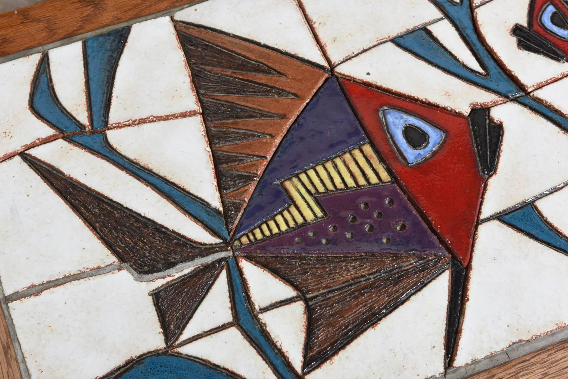 Stunning decor of stylized fish in graffito technique in glazed tiles with a teak framework on a metal black lacquered frame made by Belgian artist Paul Vermeire from Oostende. (1928-1974)

Vermeire was a student of Joost Marechal and also worked