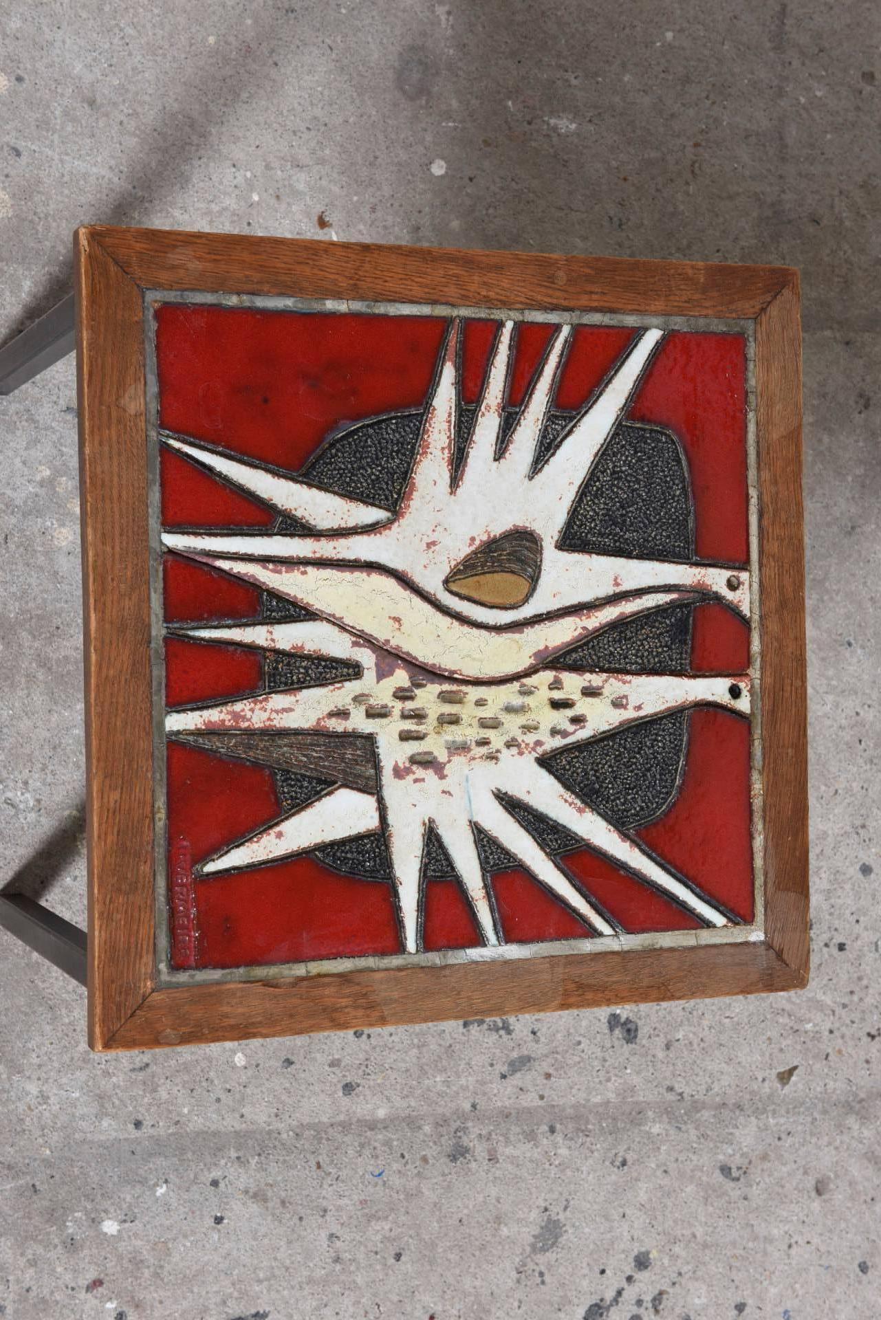 Two very original design art tables in glazed ceramic with a beautiful intense color palette of blue, brown and black the other one in red, white, black and yellow.
The tile tableaux are framed in an frame of oak on a black lacquered metal base,