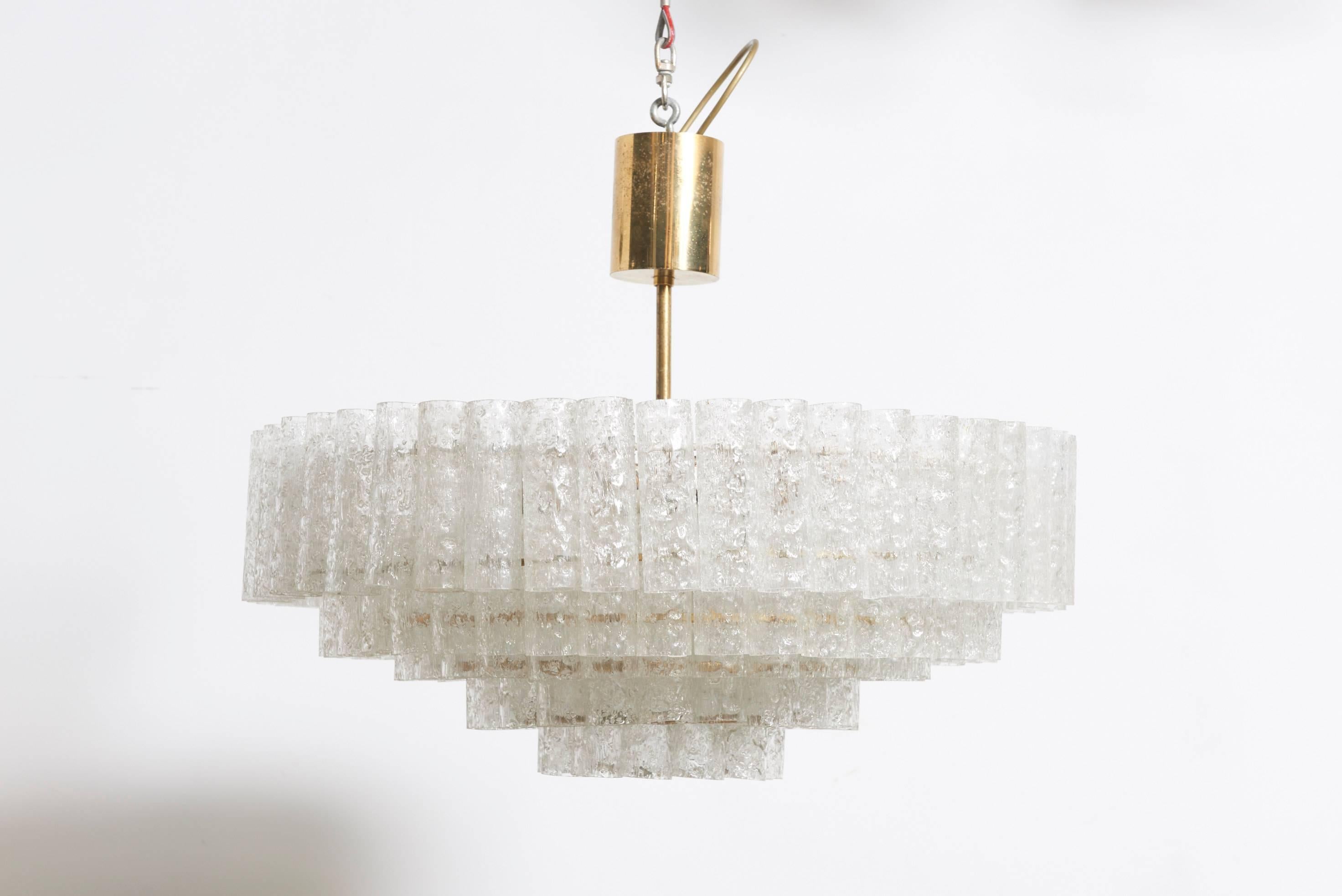 Large five tiers ice glass vintage chandelier with textured blown glass cylinders suspended on a frame in its original brass and white lacquer finish condition, labelled, by Doria, Germany, 1970s.