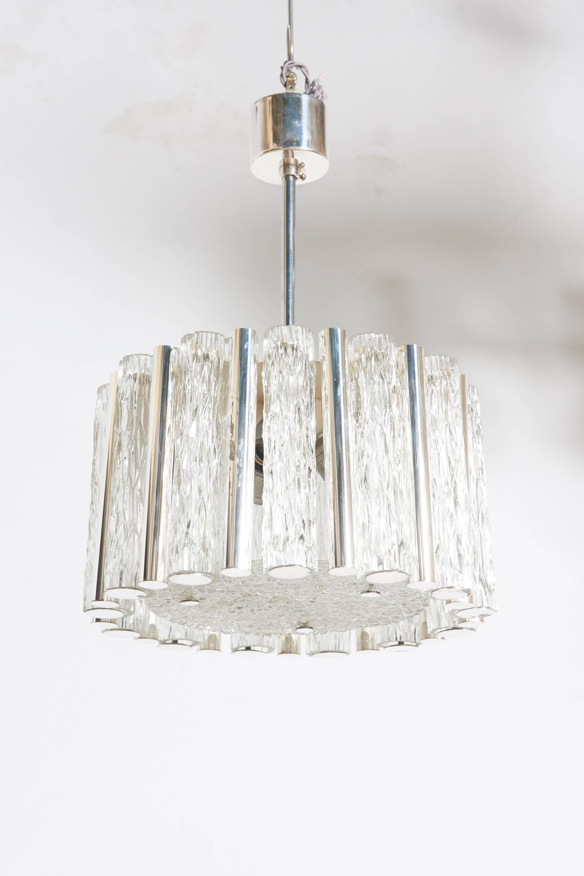 This chandelier cast beautiful light through clear patterned ice glass and warm silver plated tubes.
Very good condition, rewired.