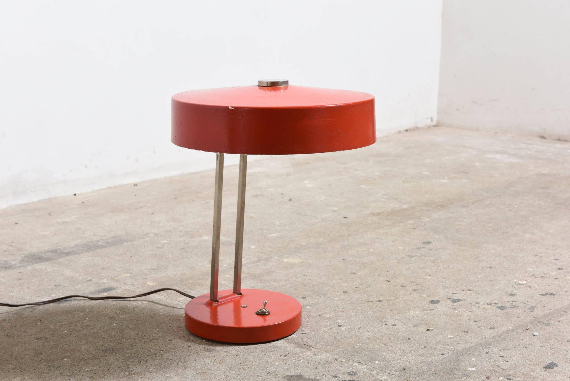 Adjustable desk lamp with an enameled emerald red shade connected by a curved chrome stem and red base by Bauhaus designer Christian Dell for Kaiser.