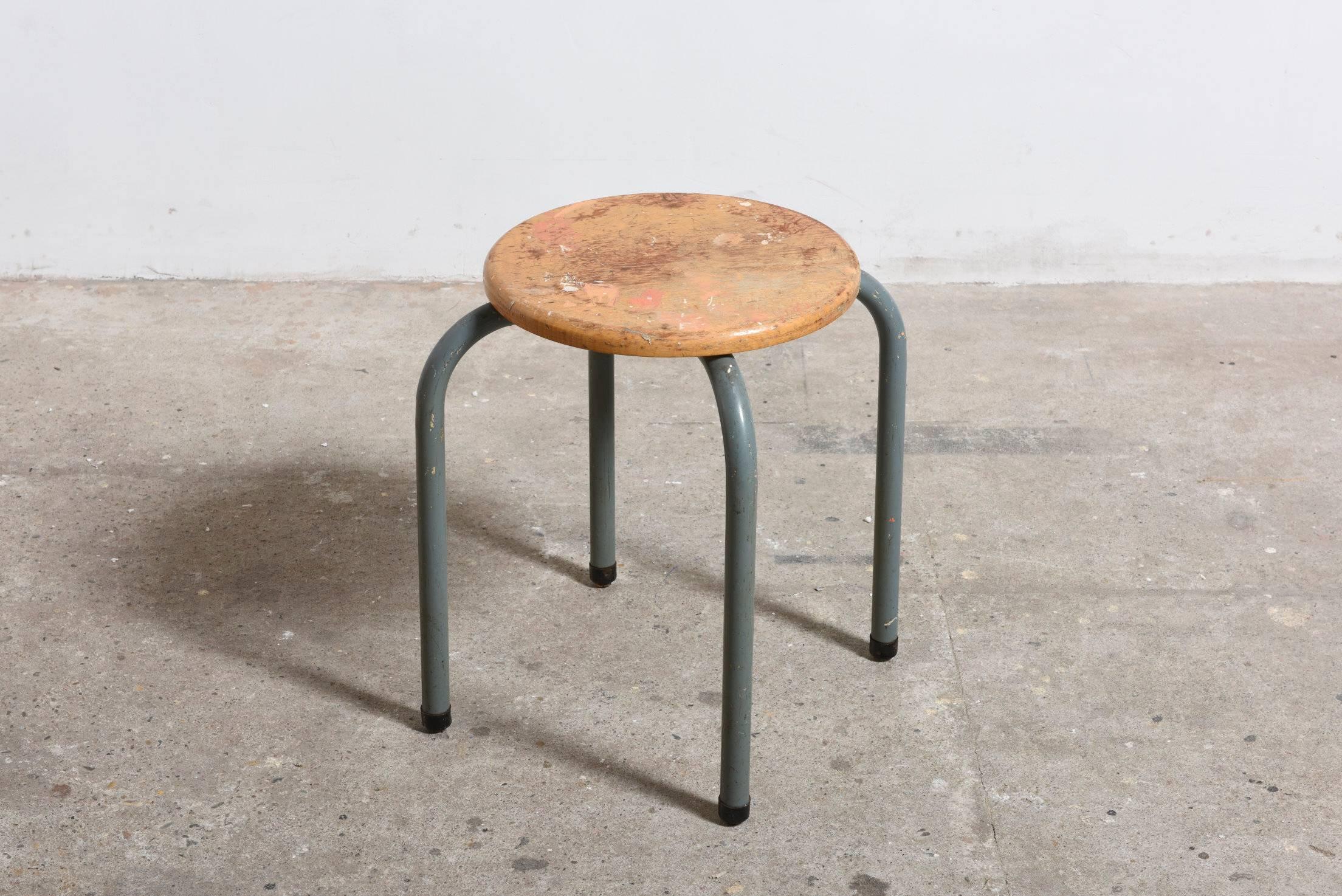 This set of stools from an artist's studio are practical in use with an characteristic Industrial look made by Tubax, Belgium.

Stools with a grey lacquered tubular metal frame and a round birch plywood seat. 
The stools are stackable and we have
