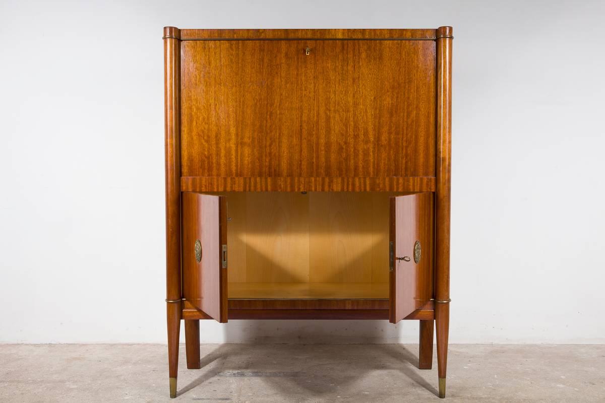 Exclusive Art Deco bar cabinet manufactured by De Coene Frères in Belgium, circa 1940 made from massive mahogany with detailed brass lines and bronze stylized appliques designed with leaves and flowers, the wooden legs are finished with a brass top.