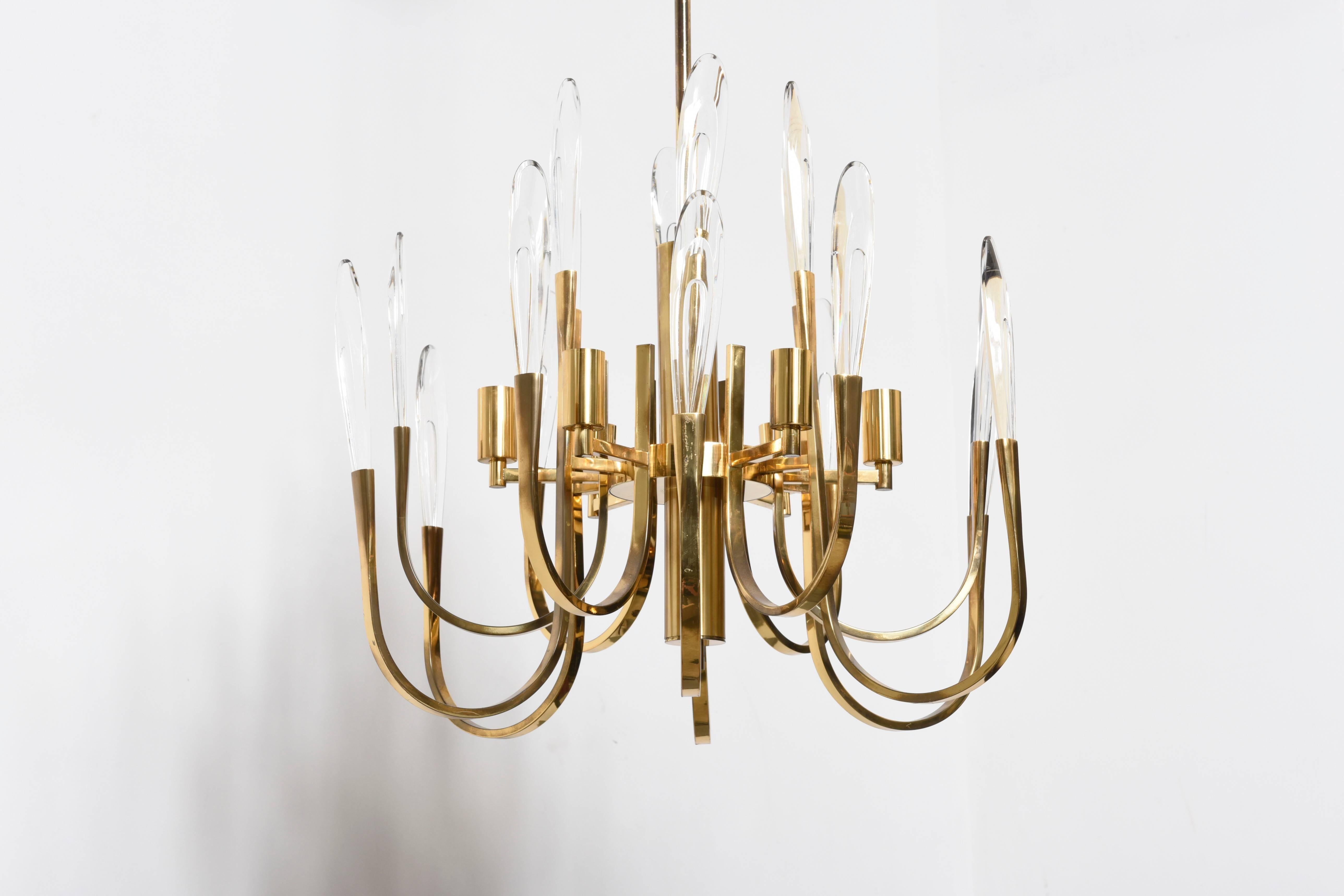 This midcentury brass chandelier was designed by Geatano Sciolari in the 1960s. 
It is constructed of two tiers brass arms with faceted crystal and holds six smaller light bulbs. 

Today the Sciolari impressive lamps and sculptures lighting can