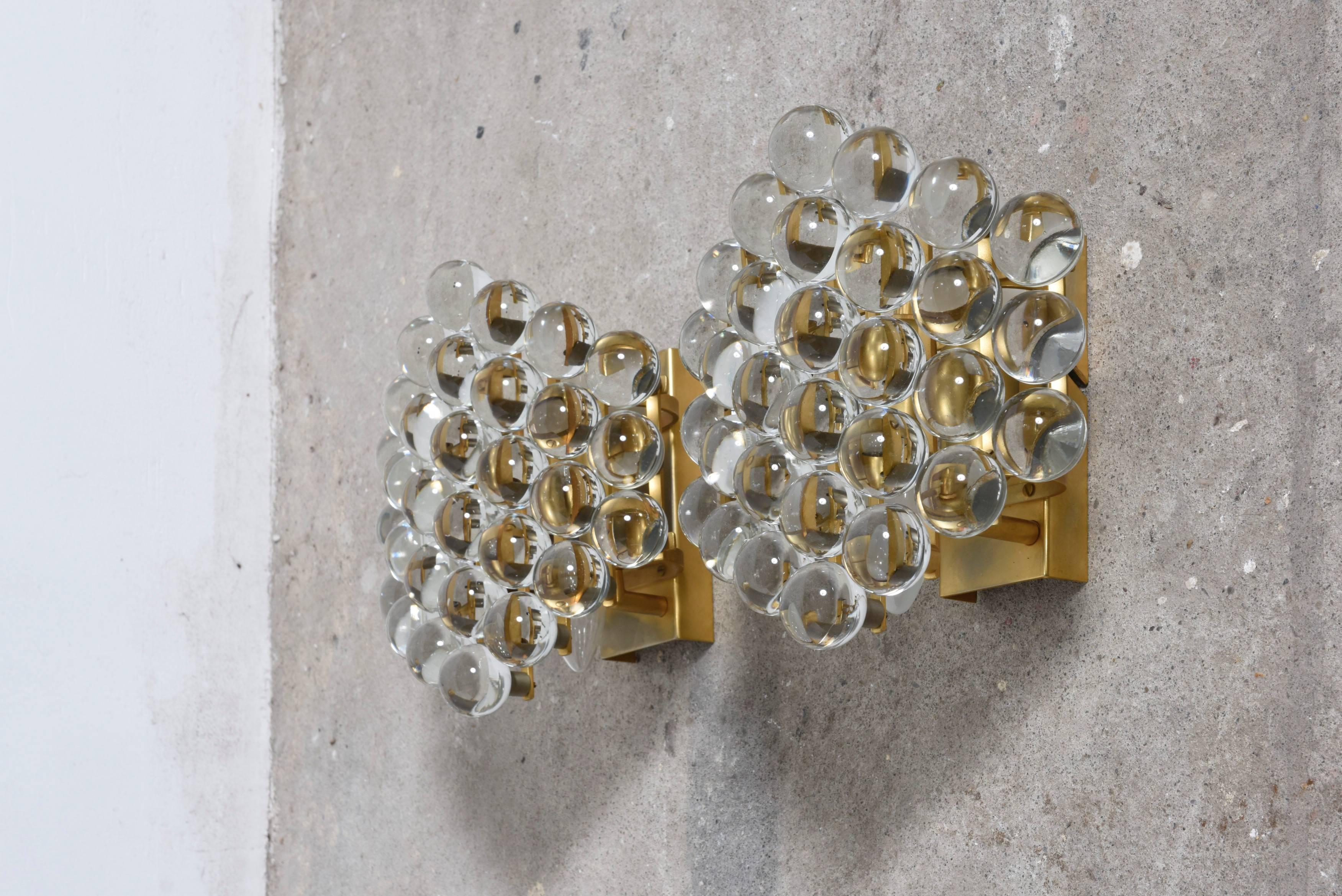 These beautiful sconces composed of Murano transparent crystal spherical glass grains attached to a gold-plated frame.
Set of two sconces designed by Palme and Walter a perfect fusion that creates an elegant lighting effect.
In very good