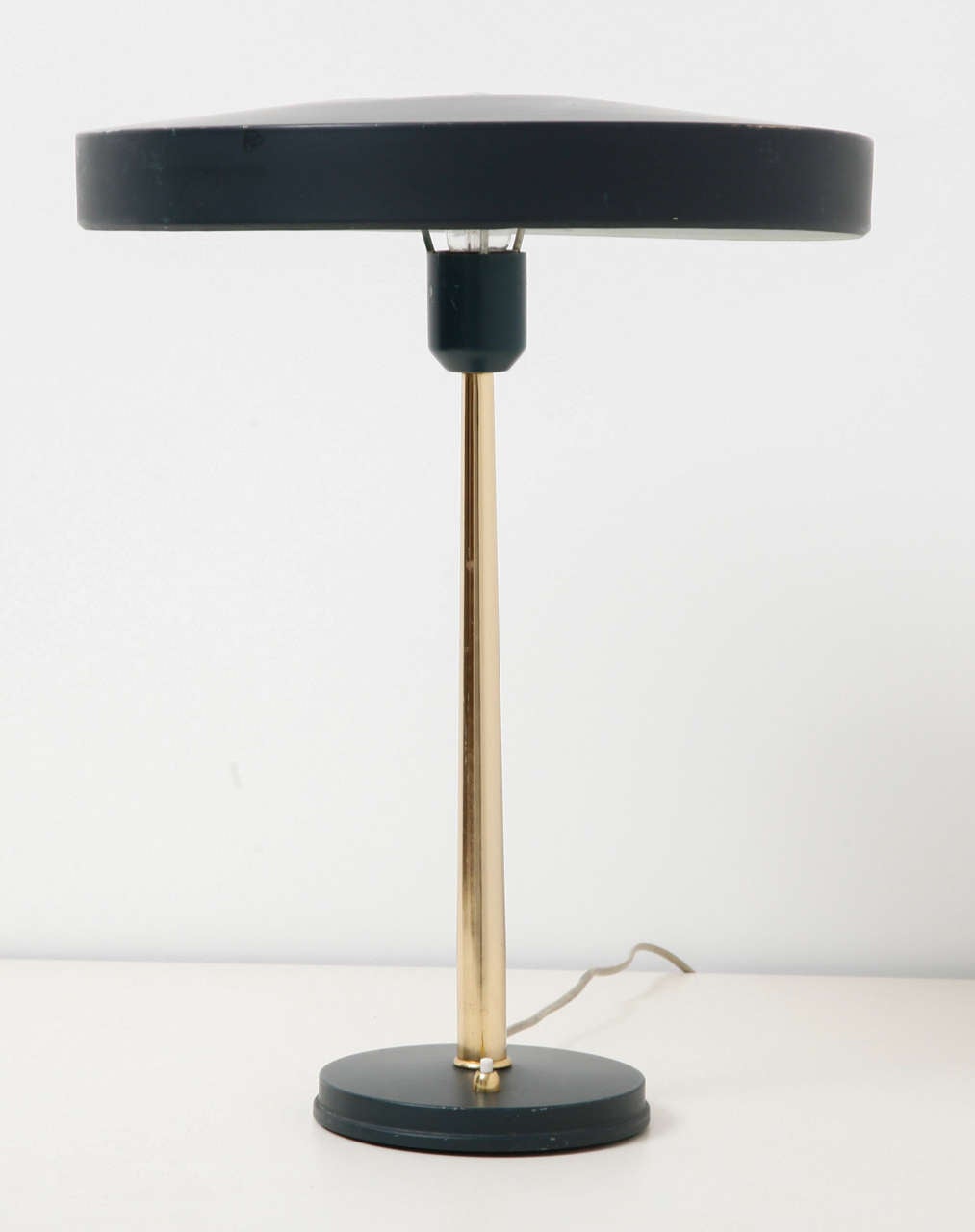 Midcentury original pair table/desk lamps in black, designed by Louis Kalff for Philips the Netherlands. 
This famous ‘Timor 69’ Dutch design features a black foot and a UFO-shaped aluminum lampshade on a gilt stem. 
The lamp foot is labeled by