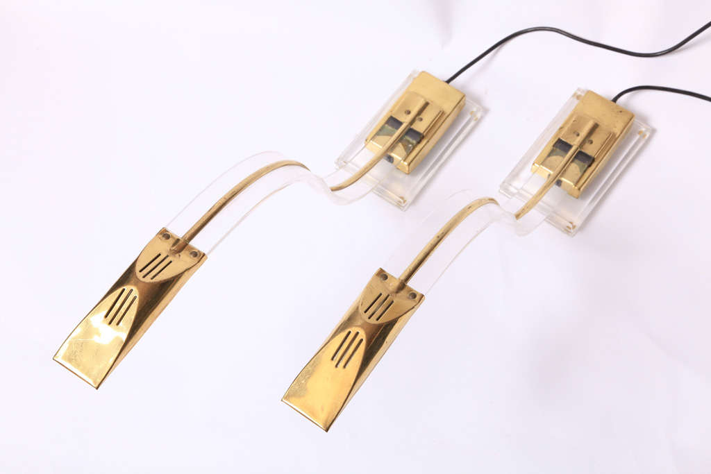 A set of two Lucite desk lamps with brass elements by Arredeluce, Italy, 1970s. A beautiful set of desk lamps with reaching halogen light to read your paper or book through the reaching streamlined gooseneck, just one position.