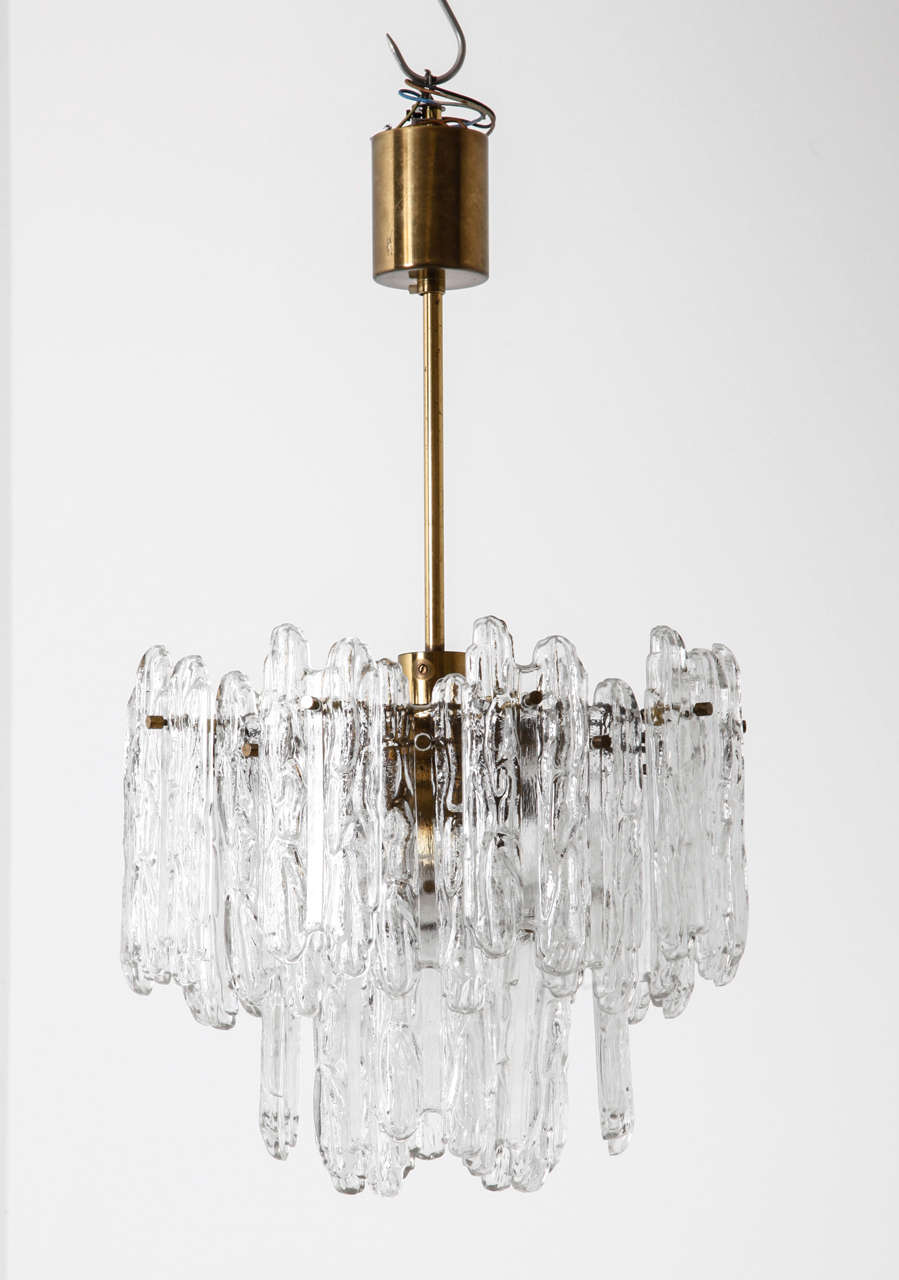 This modernist glass ice block chandelier by Kinkeldey, Germany, 1970s has a polished brass frame supports multiple glass elements.