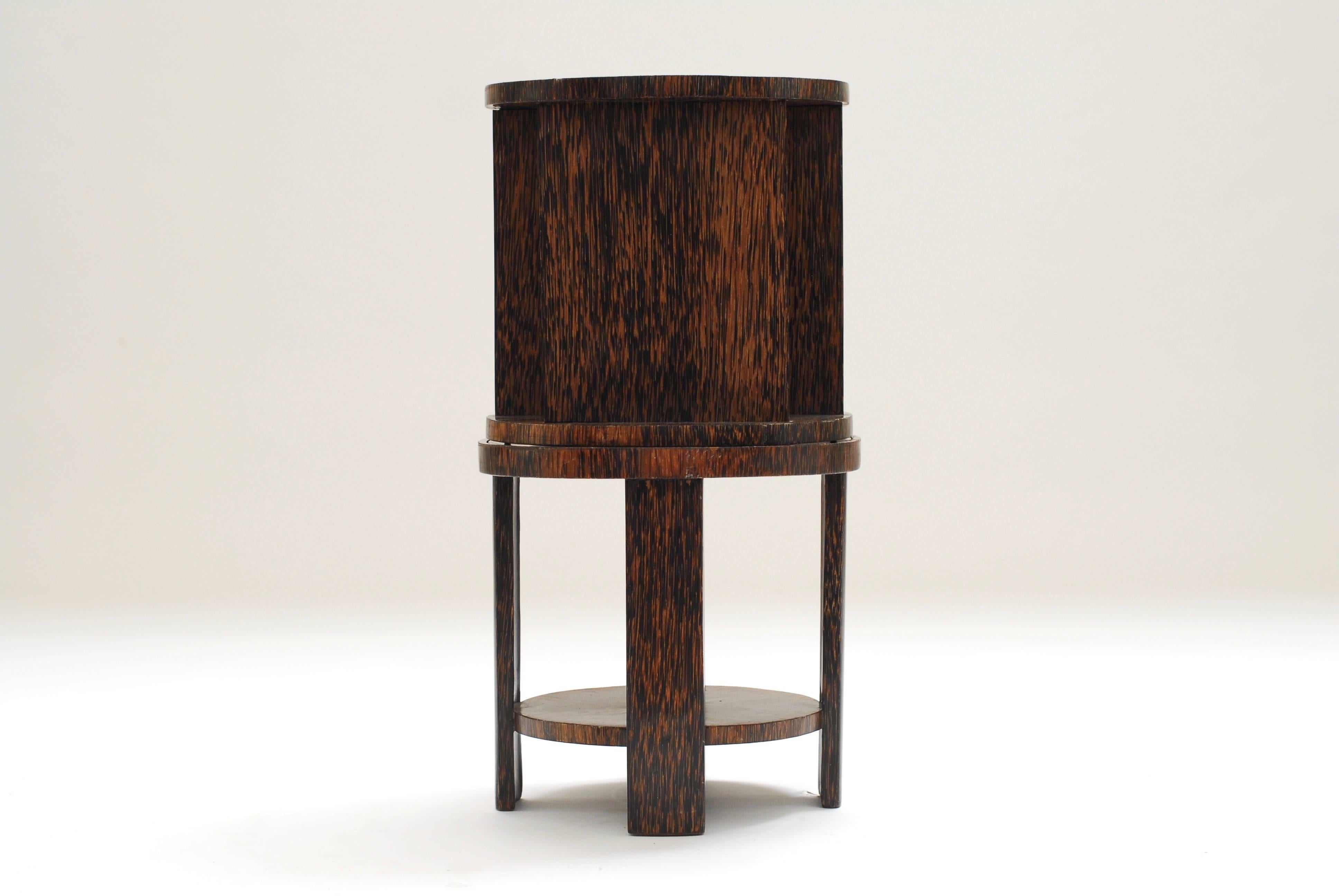 A well-proportioned and clean designed palm wood gueridon. Existing out of two pieces that inter-connect with a brass pin. The rotating finds place due to four small metal balls rolling on an integrated brass/bronze ring.
At the end of one leg