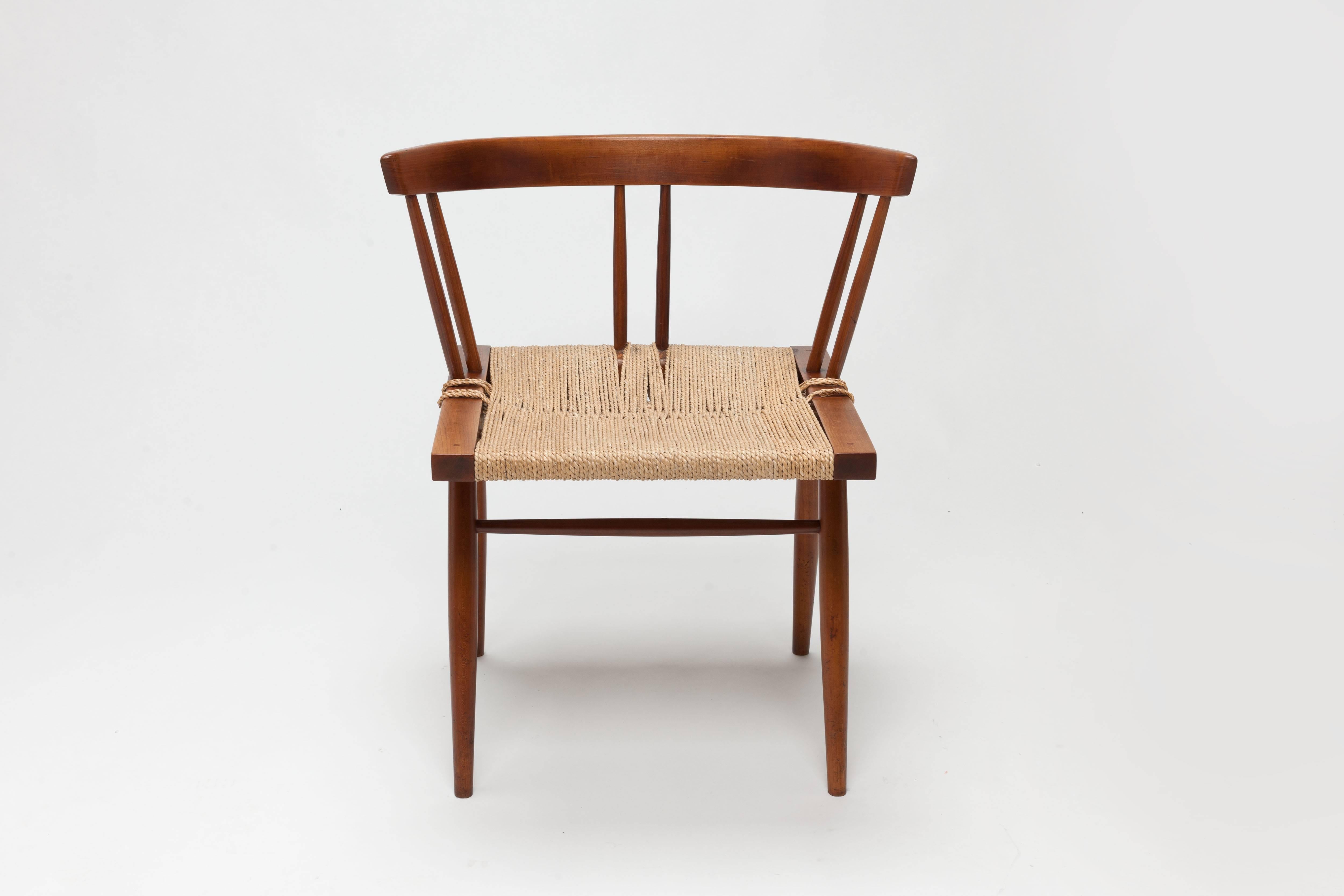 Single grass-seated chair from circa 1950s production in black walnut by George Nakashima, Nakashima Studios with original sea grass seat.