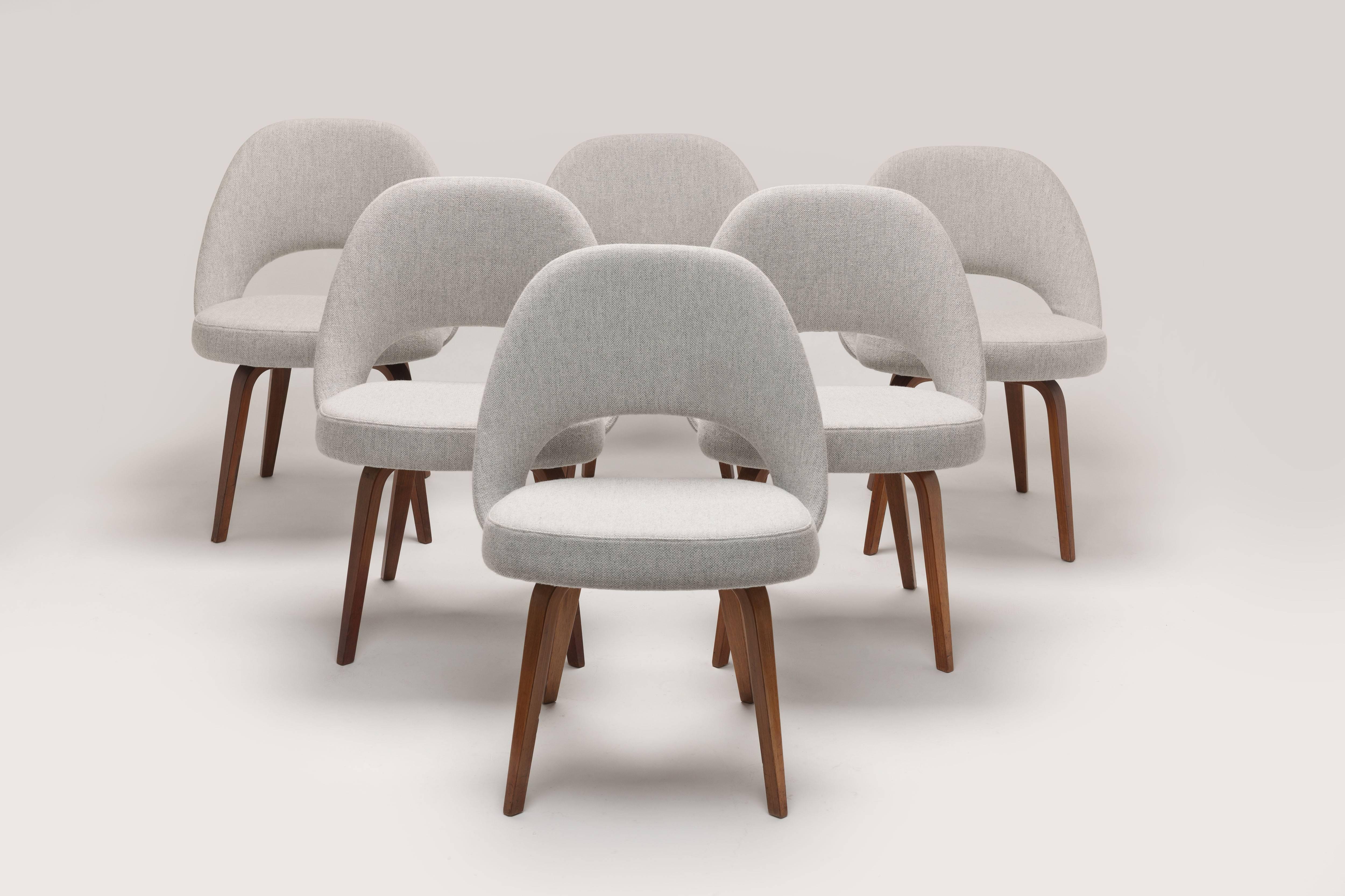 Saarinen executive chairs or model 71 with wooden legs in newer upholstery in Kvadrat 'Hallingdal' fabric. A beautiful, expensive and strong or durable fabric that is authentic to the design period.
Two out of six (6) chairs still carry the early