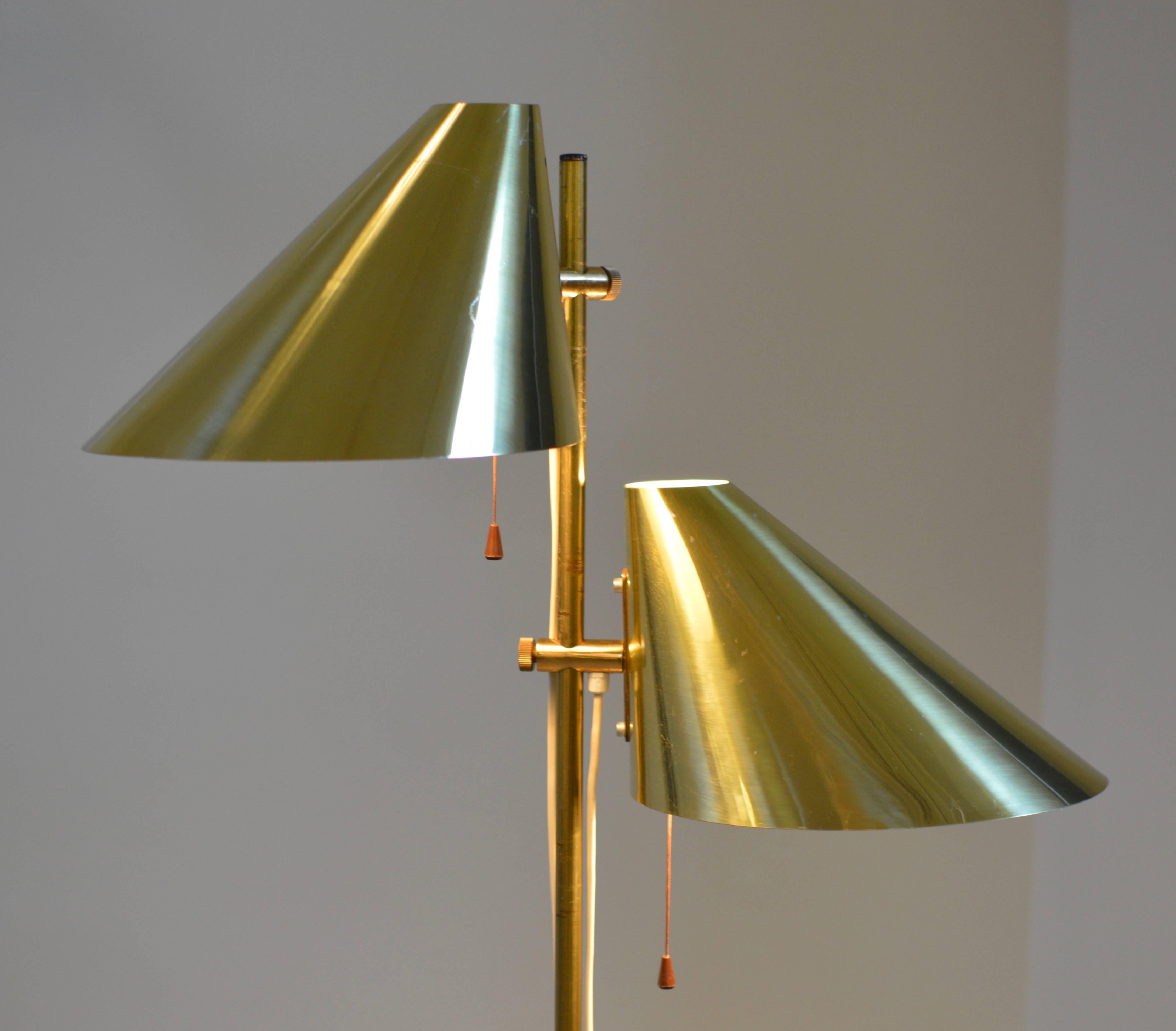 Brass double shade floor lamp by Hans-Agne Jakobsson for Markaryd, Sweden according marking/label in shade (see photo # 9).
Both shades are individually height adjustable and rotatable and can be switched on and off individually. 

Lamp comes