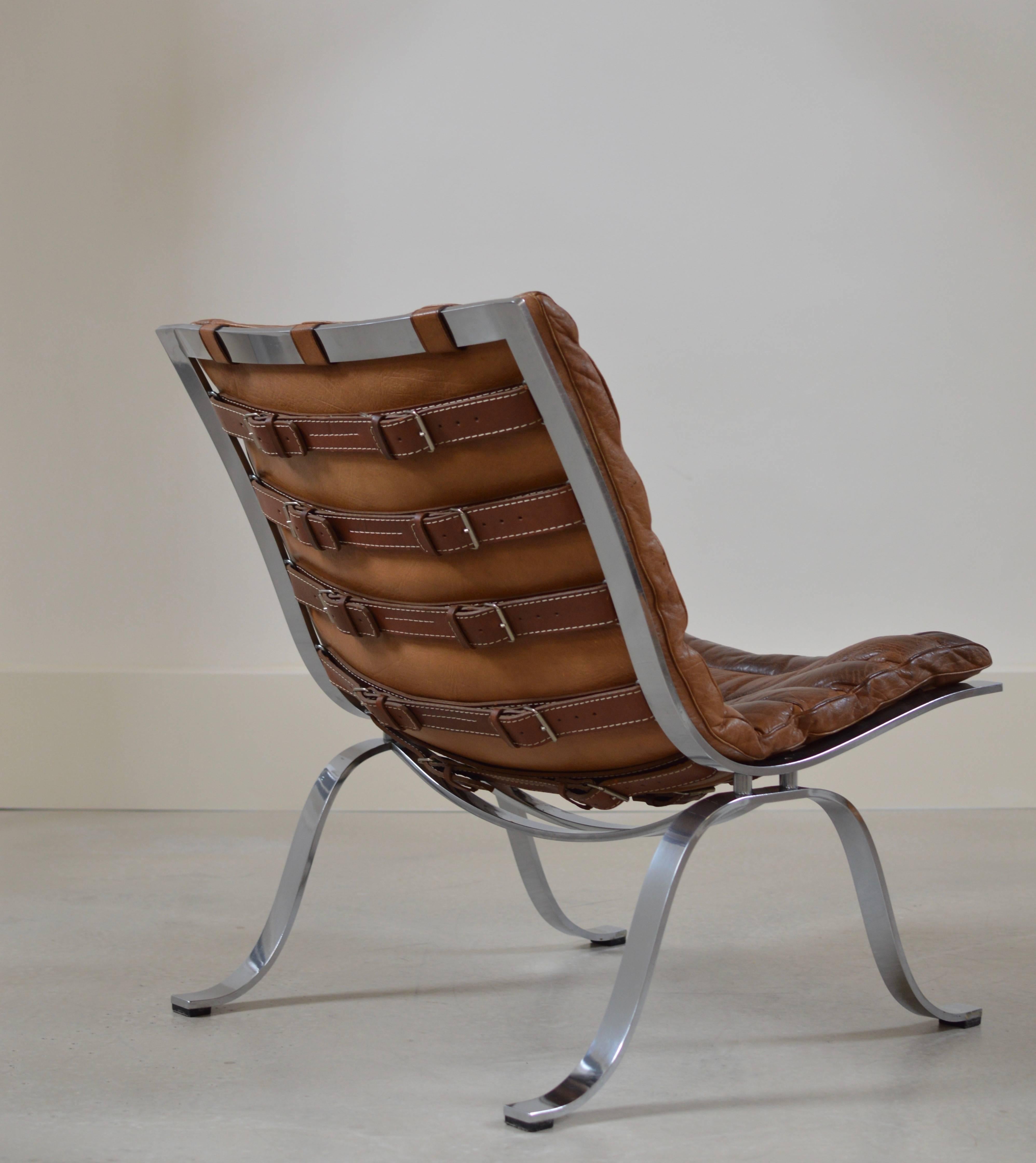 Rarely seen 'Ariet' Lounge chair by Swedish Designer Arne Norell in a beautiful brown patinated buffalo leather and finest high gloss chromed frame. 
Please note the beautiful belts with buckles, this distinct detailing gives the chair a beautiful