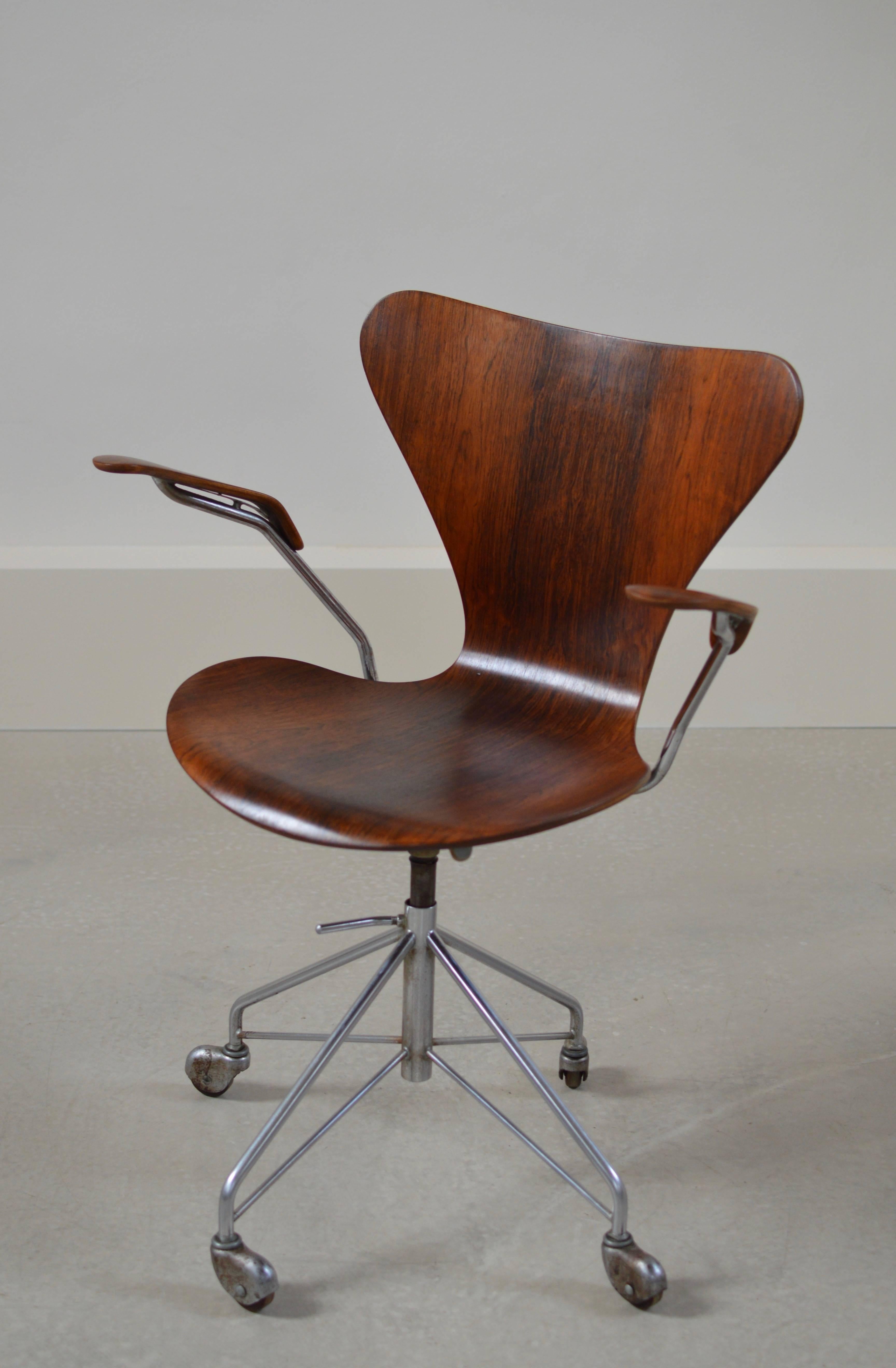 Rare rosewood edition swivel desk chair with armrests, model 3217 on four caster chromed swivel base. Originally designed in 1955, executed (as marked) by Fritz Hansen, Denmark. 
Chair is manually in height adjustable. Seat height when photographed