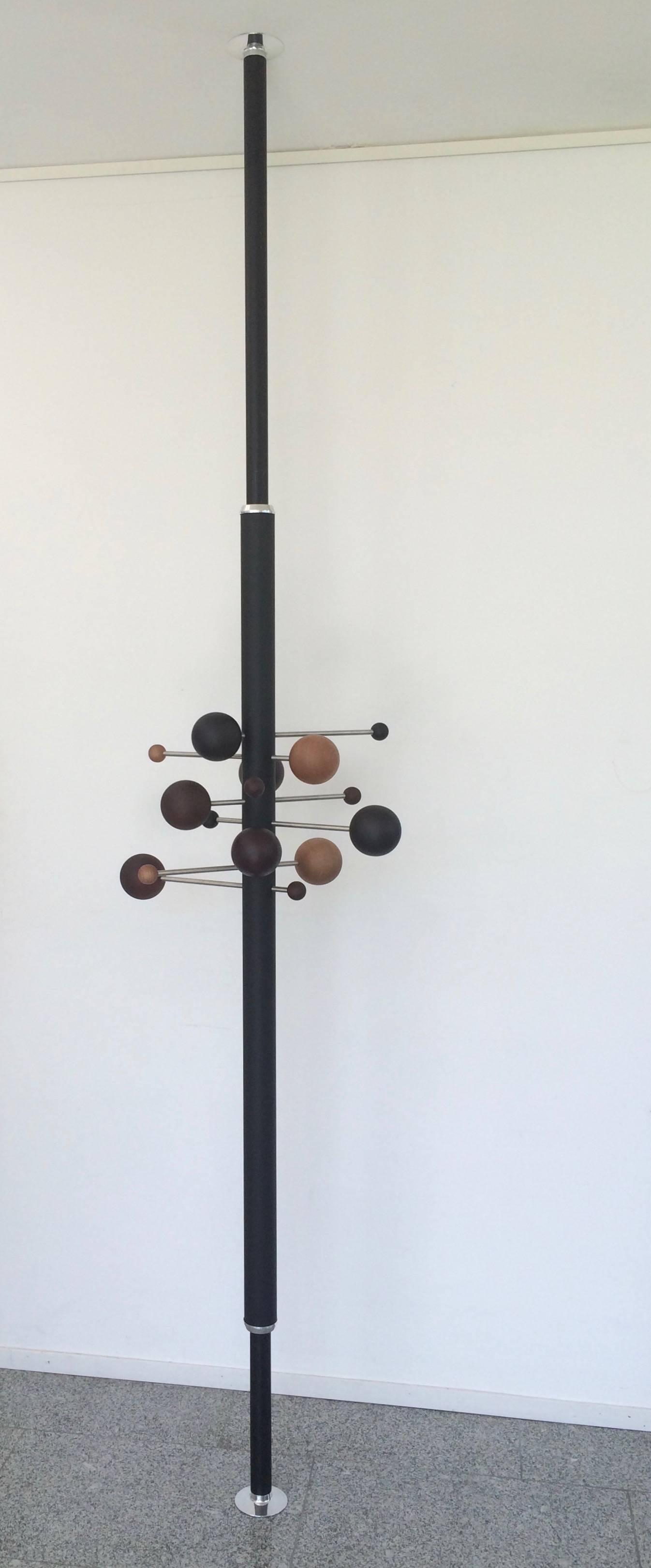 Coat rack model AT16, designed in 1961 by Italian designer Osvaldo Borsani, is a compressed rotating coat hanger composed of two interlocking leather covered aluminum tubes with brushed stainless steel rods with coat hanger balls on either end. Rods