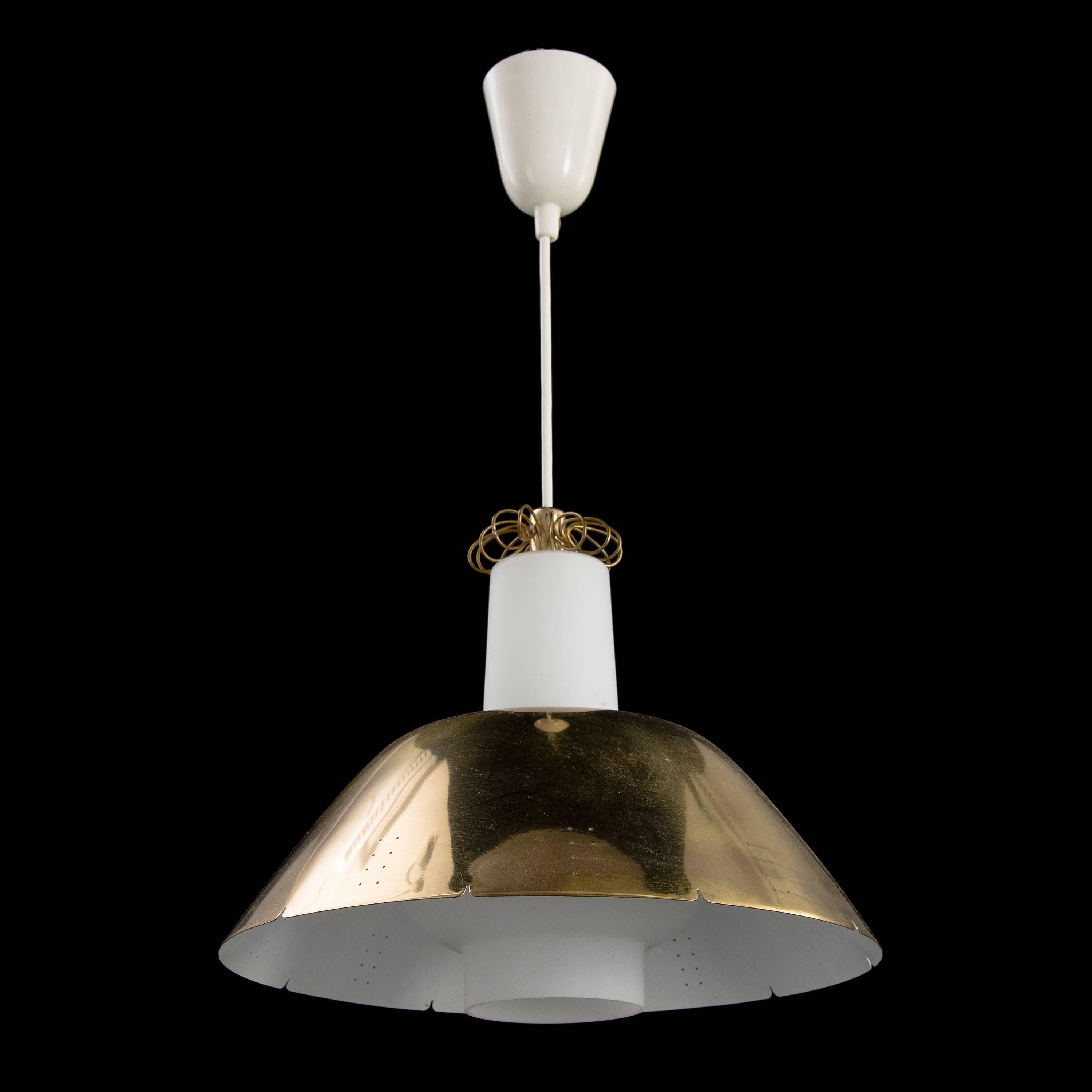 Brass and opal glass pendant by Finnish designer Paavo Tynell for Idman Oy.
Polished and perforated brass shade over frosted glass diffuser with bras detailing. Manufacturing period mid-1950s.
