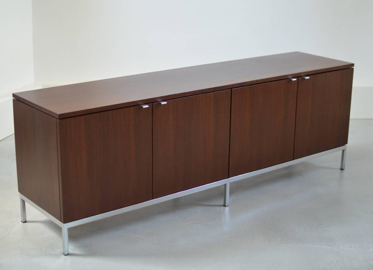 Beautiful four-door credenza by Florence Knoll for Knoll International in elegant rosewood with plain pulls on a beautiful seamless base. 
An early unrestored 1960s example in wonderful condition. 
Credenza comes with original Knoll manufacturer's