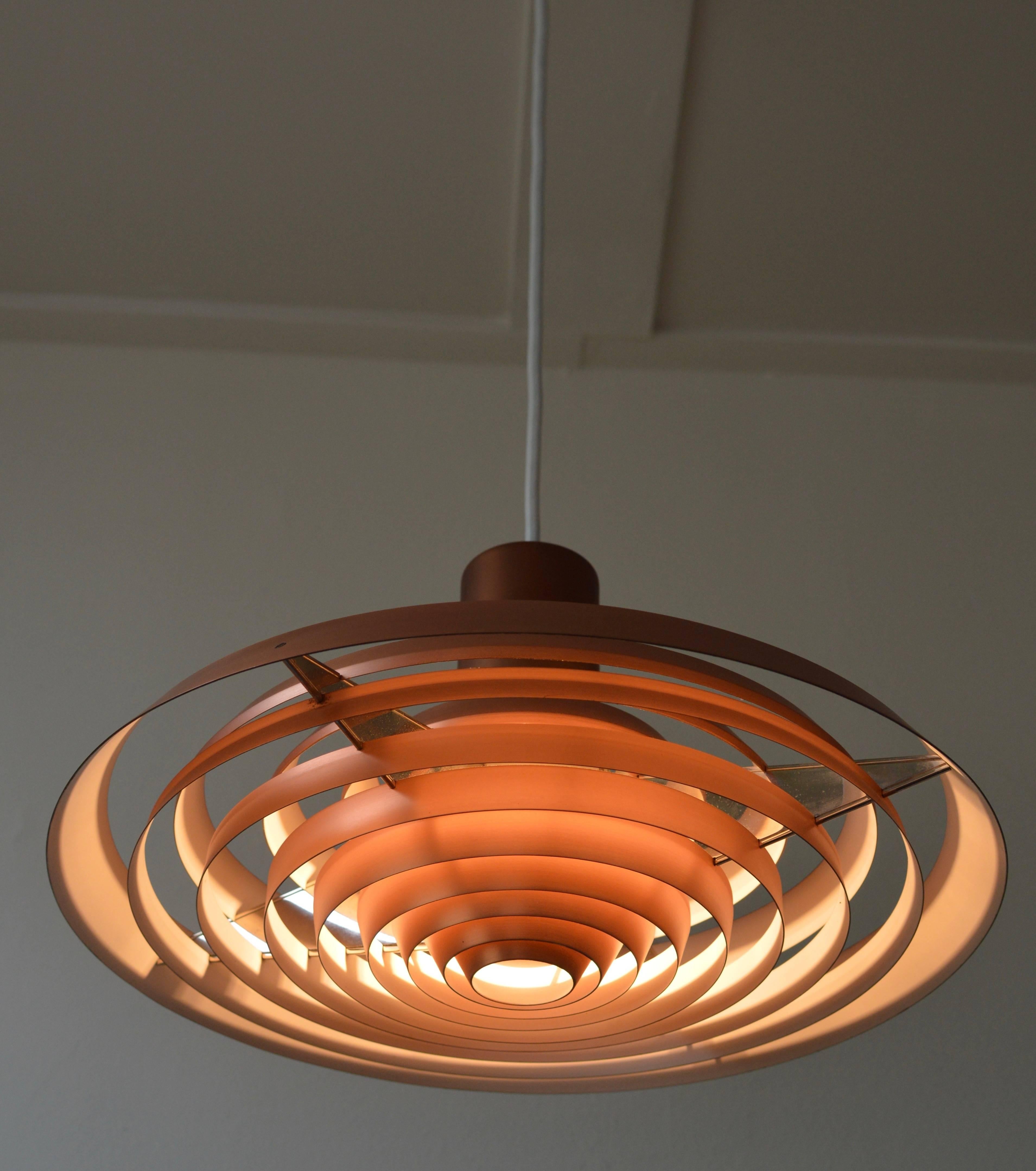 Beautiful copper Langelinie plate pendant by Poul Henningsen for Louis Poulsen originally designed in 1958 for the Langelinie Pavilion in Copenhagen and inspired by the pattern of rings in the water surrounding the Pavilion.
This lamp was produced
