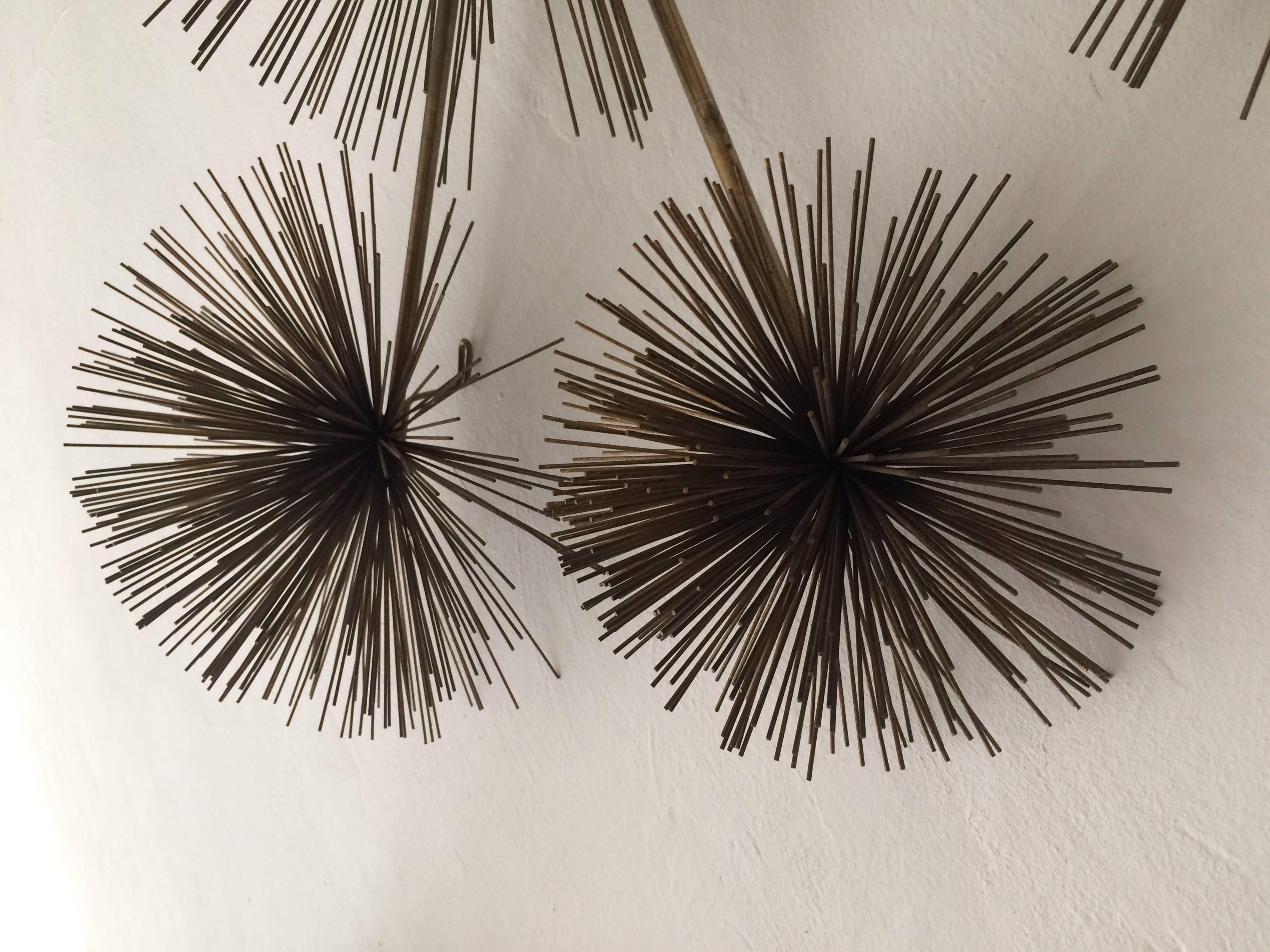 Metal 'Pom Pom' or 'Sea Urchin' wall sculpture executed in brass, fully signed and dated, 'C Jere 1979.' 
Sculpture can hang by one to three hooks in horizontal or vertical.