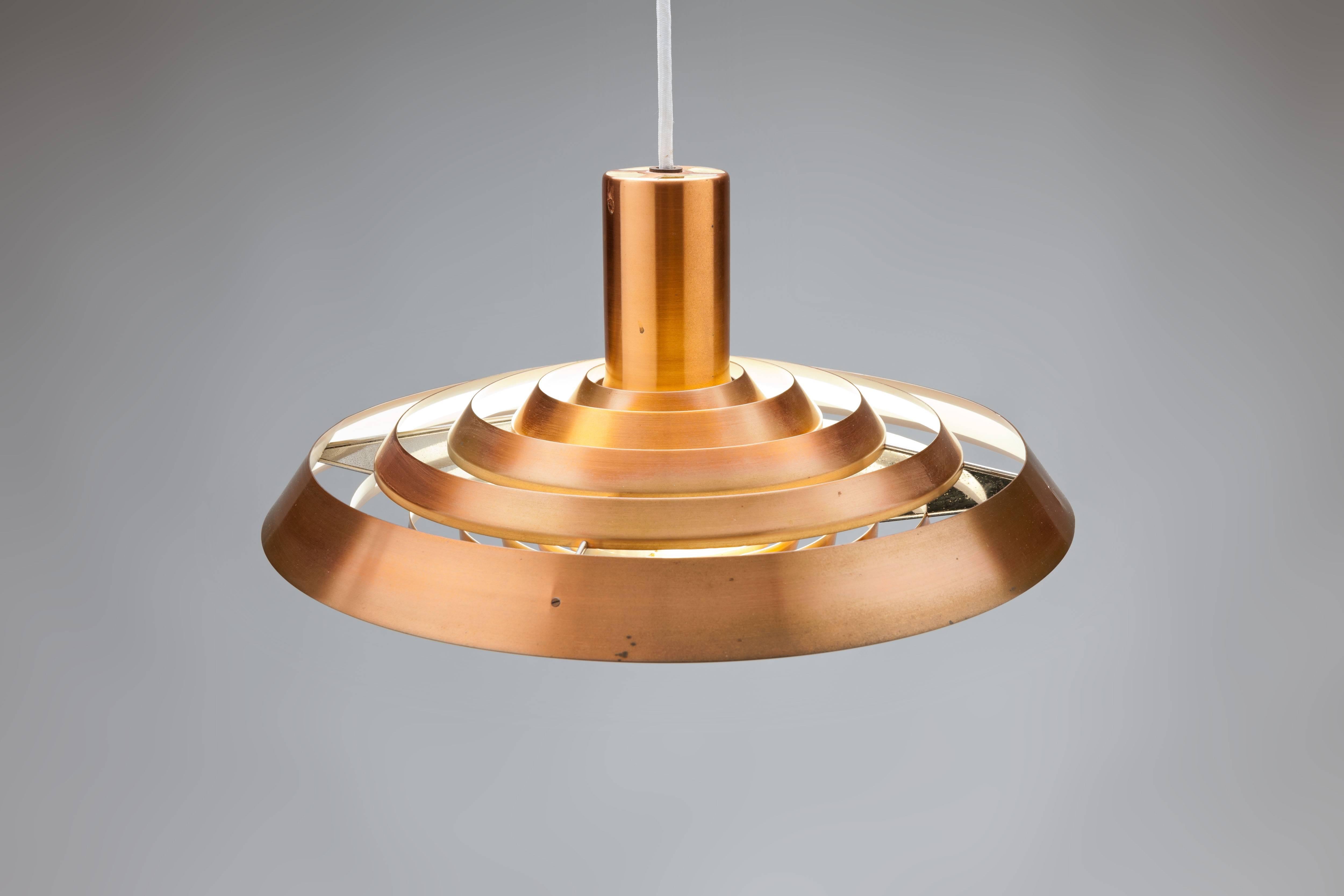 Copper Langelinie plate pendant by Poul Henningsen for Louis Poulsen originally designed in 1958 for the Langelinie Pavilion in Copenhagen and inspired by the pattern of rings in the water surrounding the Pavilion. This lamp was produced in the same