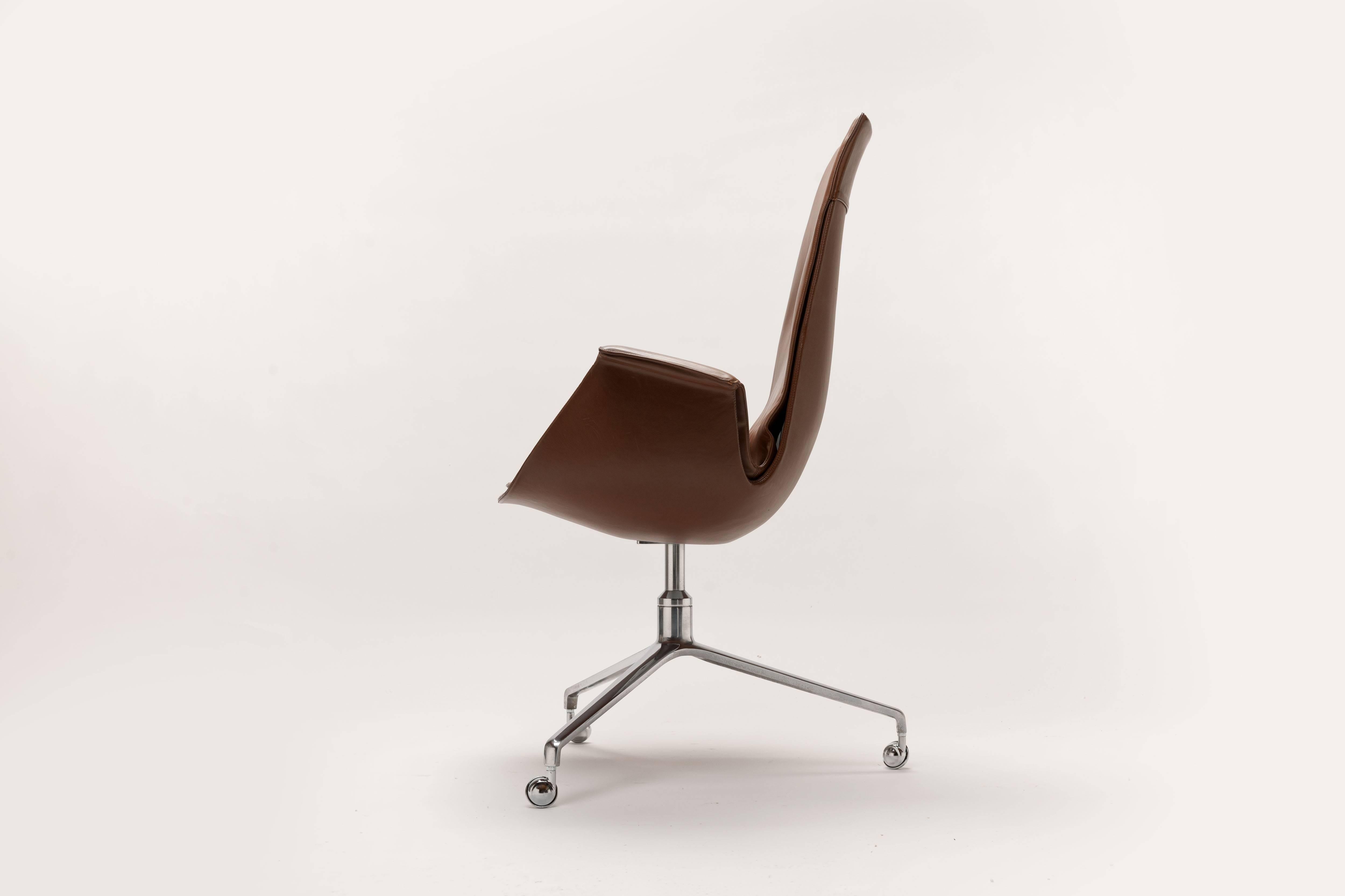 Beautiful original brown leather swiveling high back desk chair by Preben Fabricius & Jorgen Kastholm on signature tripod cast aluminium base with castors.
This is the original and first execution with the three legged base and metal castors.