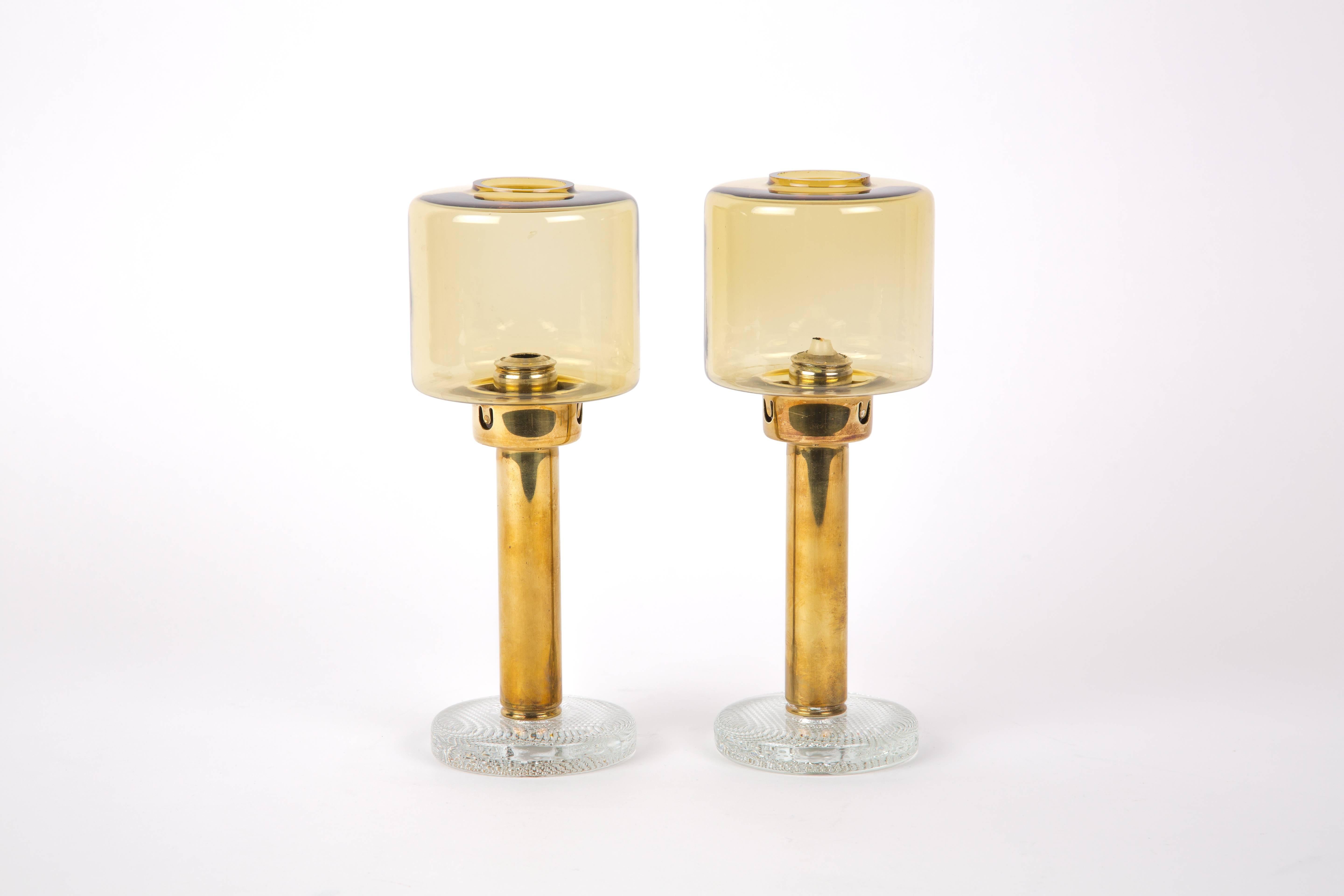 Hans Agne Jakobsson. A set of two brass candleholders with glass base by Hans-Agne Jakobsson for Markaryd, Sweden. The base is of glass with little air bubbles in it. String system for the candle.
Measures: The base is 10 cm, the height is 27 cm.
