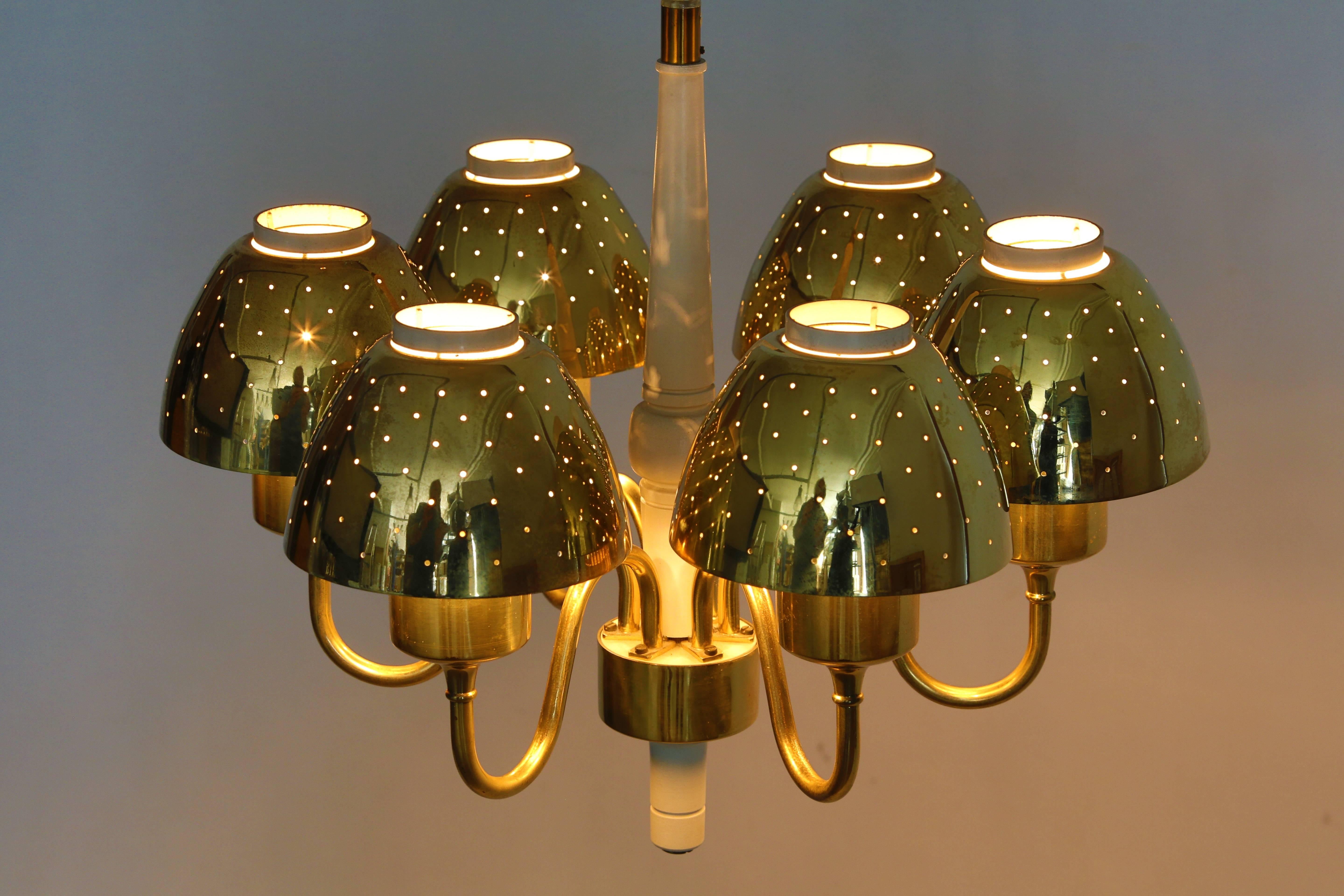 HANS AGNE JAKOBSSON brass pendant. A pendant designed by Hans Agne Jakobsson for Markaryd, Sweden. The lamp has six brass chalices. The chalices have lots of holes to make diffuse and romantic light. The center is of white painted wood. A real