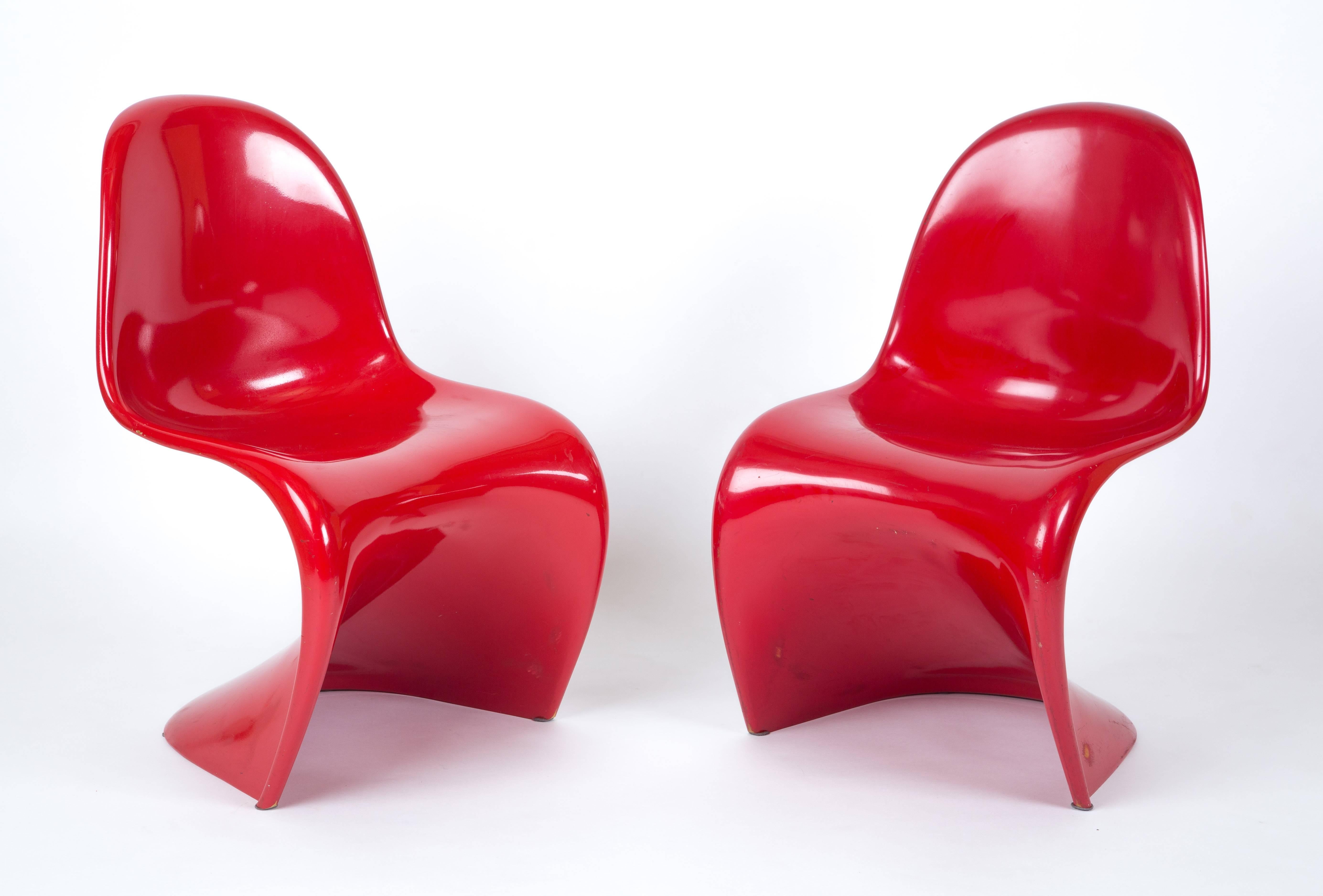 A set of two of the first edition (1960) polyester glasfiber construction. Painted in the top red color. Herman Miller collection. Iconic chairs. On the bottom you can see the polyester. Price is for the set.