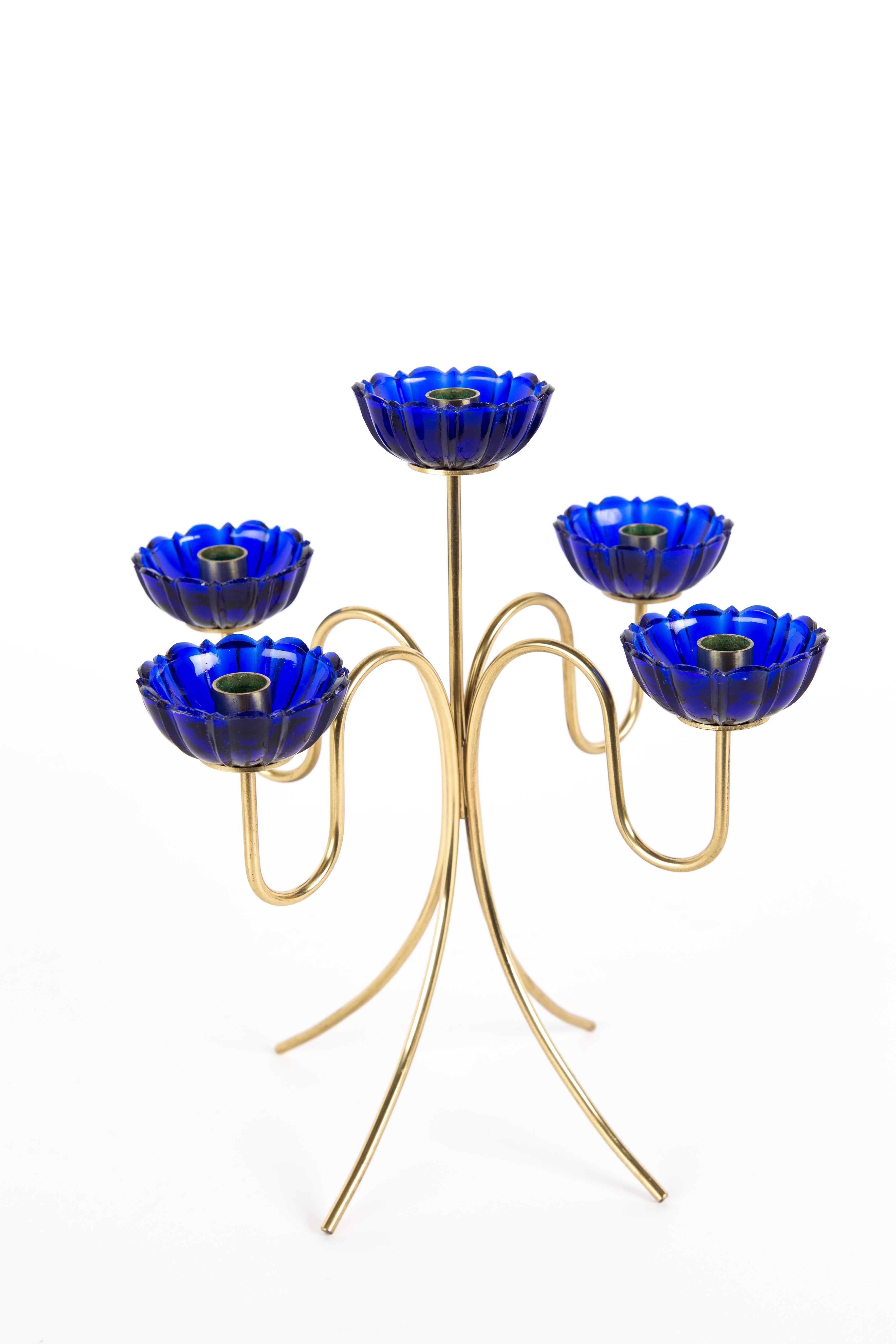 GUNNAR ANDER CANDLE HOLDER. Candle holder with four legs in brass. The blue transparent glasses are like flowers. Five glasses.
Swedish designer Gunnae Ander for Ystad Metall.