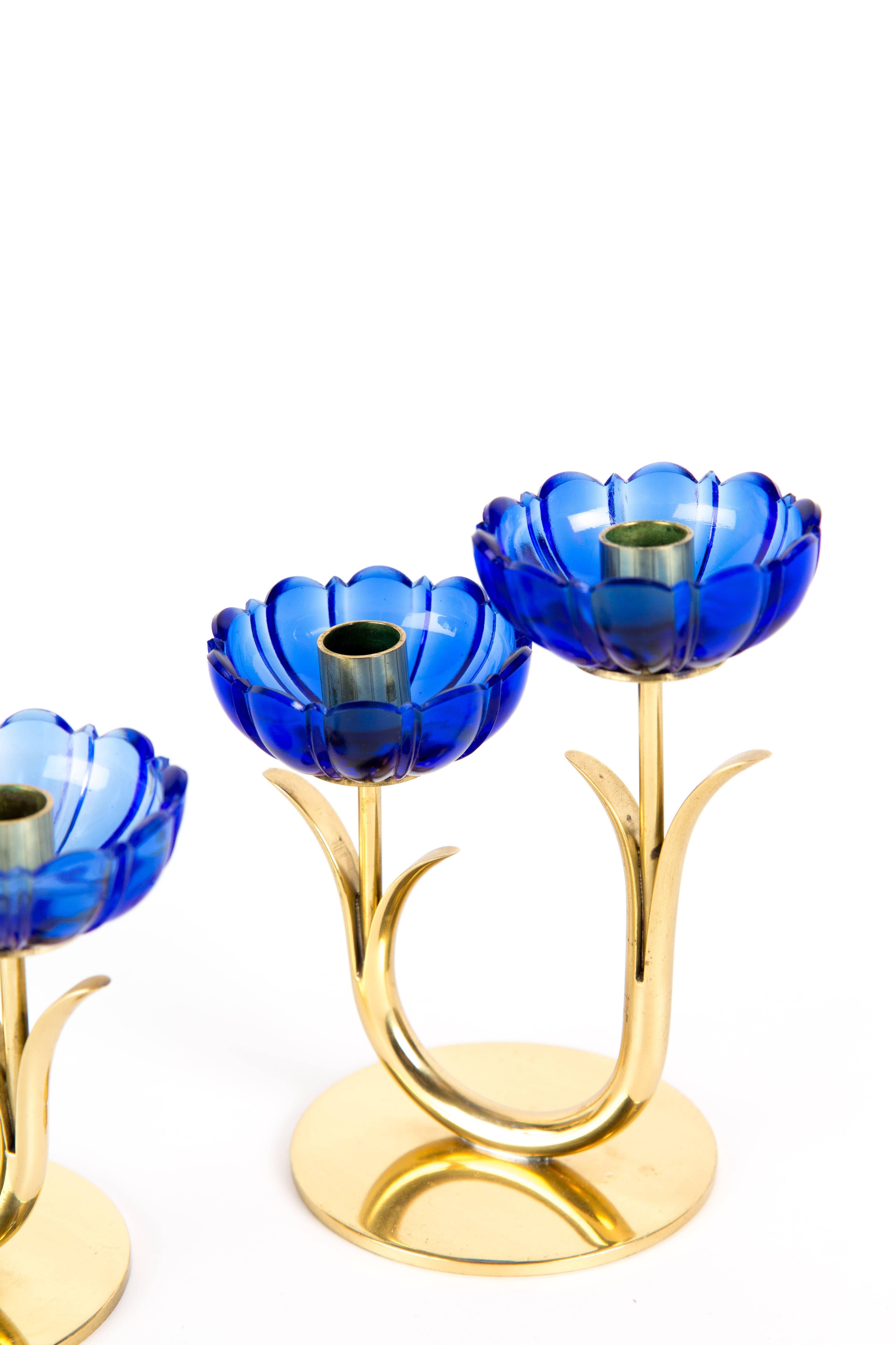 GUNNAR ANDER CANDLEHOLDERS. A set of two candleholders with blue transparent art glass. One double and one solo. Designed by Gunnar Ander for Swedish Ystad-Metal. The set is marked on the bottom. The price is for one set of flowers (three flowers).