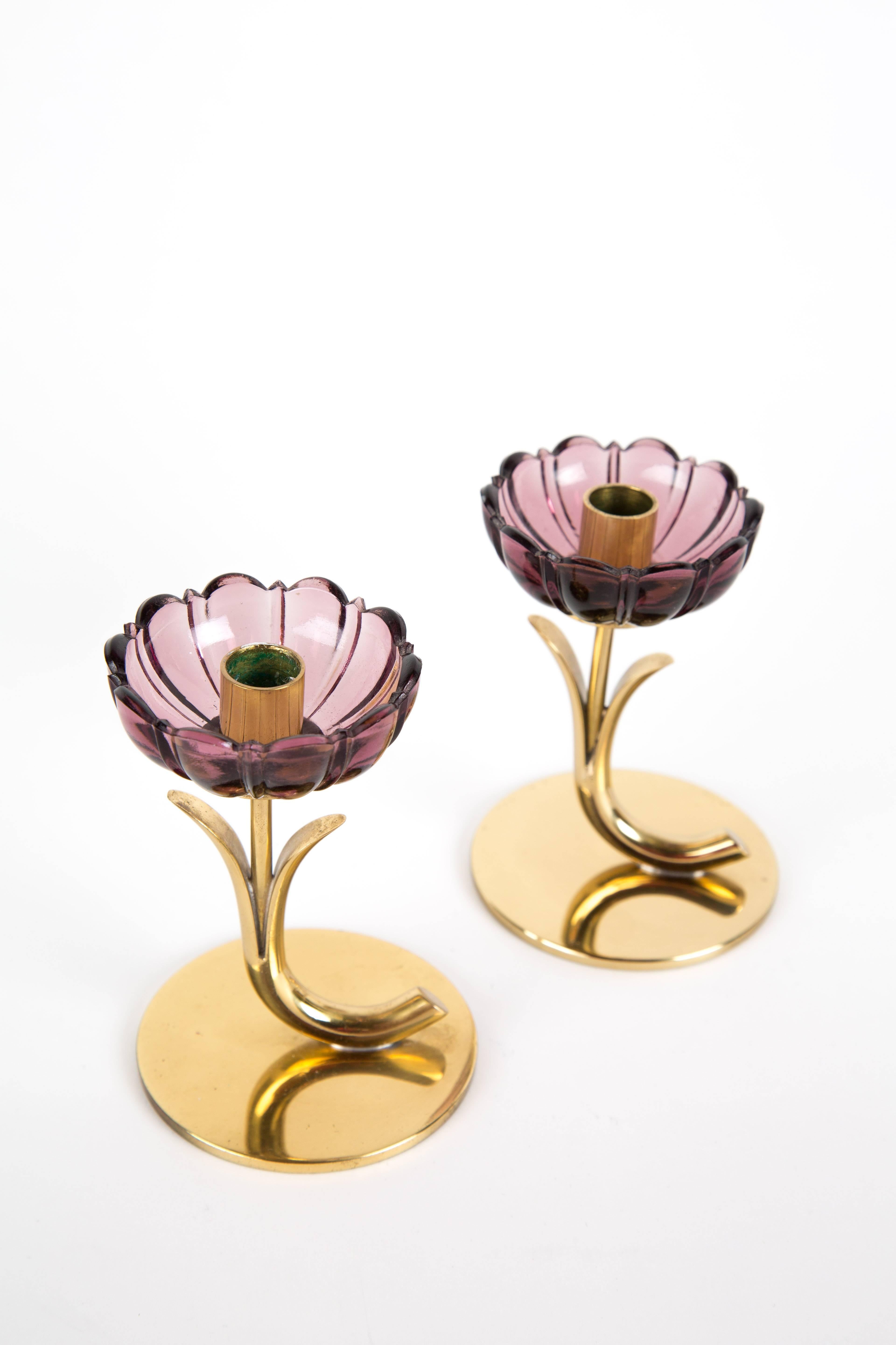 A set of two Gunnar Ander candleholders. The base is of brass. Signed in the bottom. The glass is transparent in flower-form. The price is for a set of two.