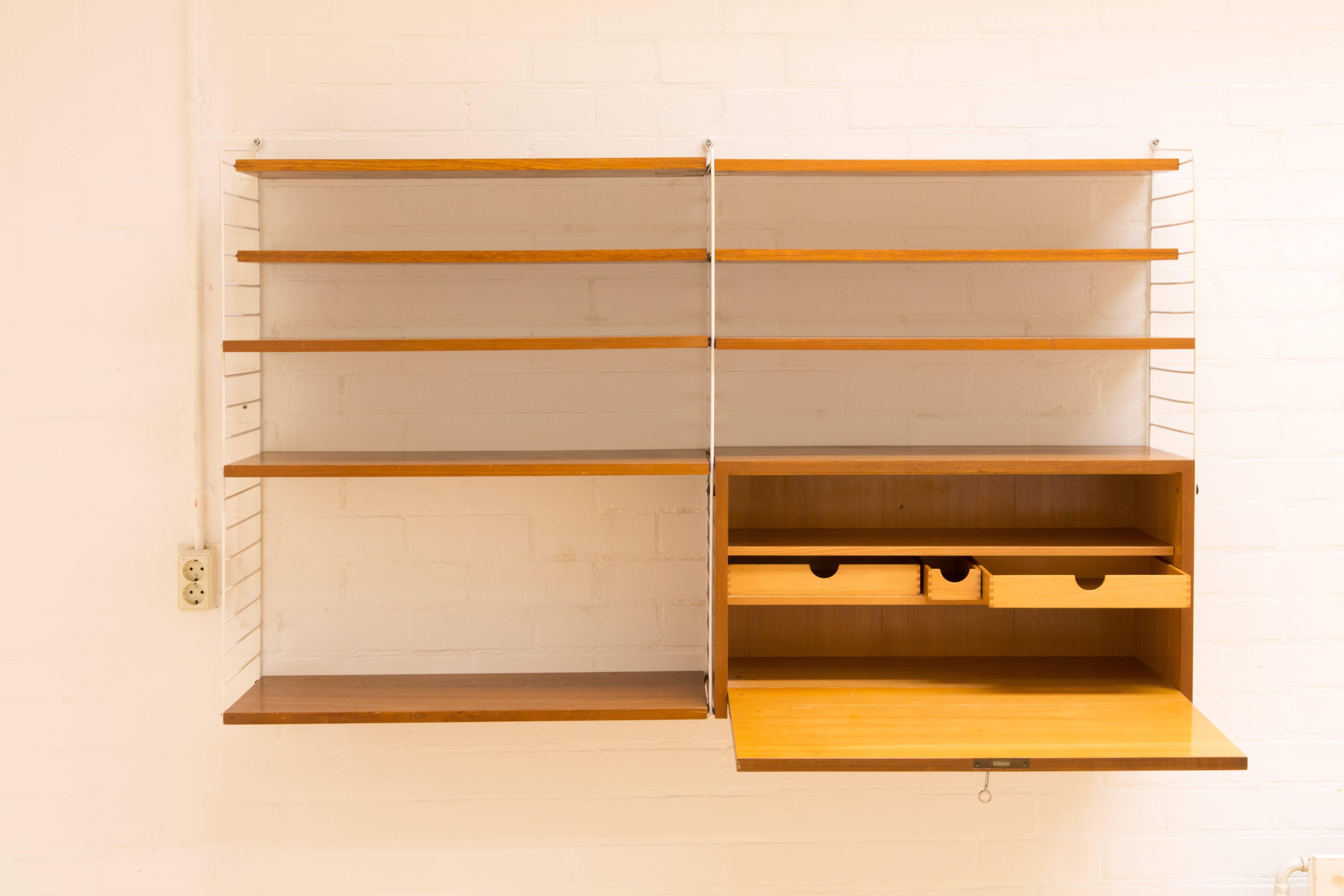 STRING WALL SYSTEM.  The system uses copper parts to connect the shelves with the basic parts. Very nice construction. The most real color is to be seen on the third photo. Four shelves 30cm by 78cm, four shelves 20cm by 78cm. A desk 30cm height,