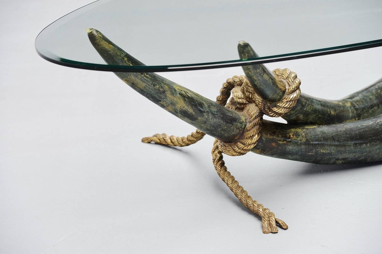 Fantastic and large coffee table designed by Italy Valenti for Valenti, Spain, 1975. This table is made of solid bronze, partly patinated in greenish finish. The solid bronze rope is stabilizing the ensemble. The oval glass tabletop is made from