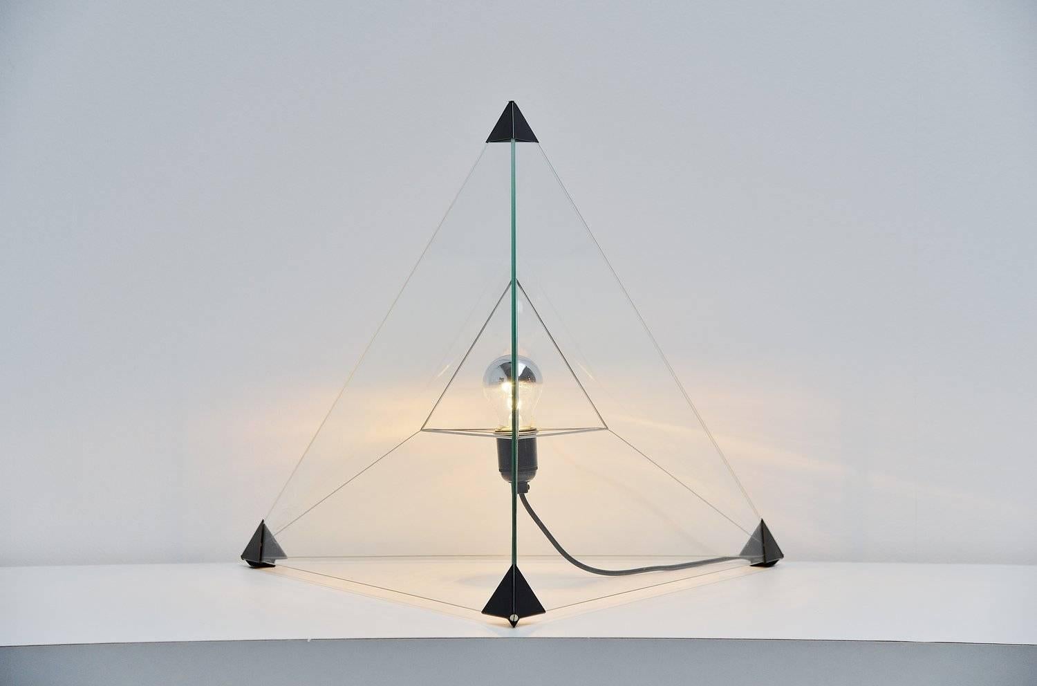 Amazing table/floor lamp designed by Frans van Nieuwenborg & Martijn Wegman for Indoor 1979. This amazing lamp exists in three triangle shaped glass plates supported by the black plastic ends and the metal wire inside. Its an ingenious system and it