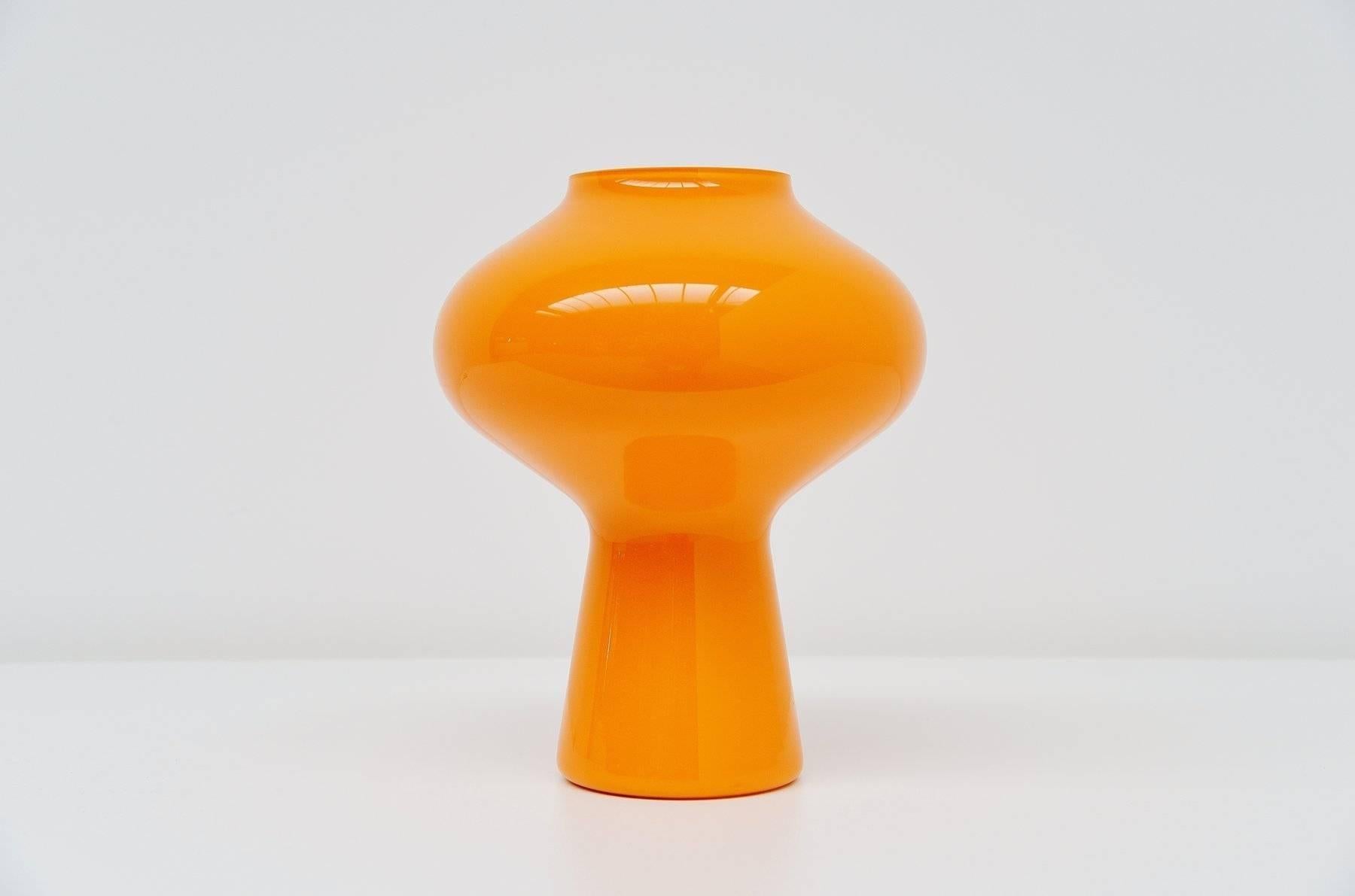 Medium sized Fungi table lamp designed by Massimo Vignelli for Venini Murano, Italy, 1960. This is the middle size of the three sizes that were made. Its made of very nice bright orange glass and gives very nice warm light when lit. Very nice and