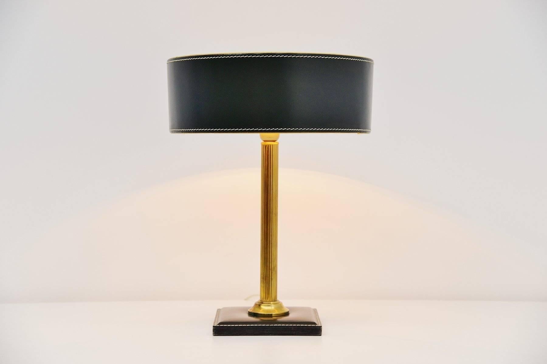 Very nice and highly decorative table lamp designed by Jacques Adnet, France 1960. This leather clad table lamp has a square shade and a brass stem, the shade is made of leather too. High quality stitching on this lamp. The lamp is in dark green