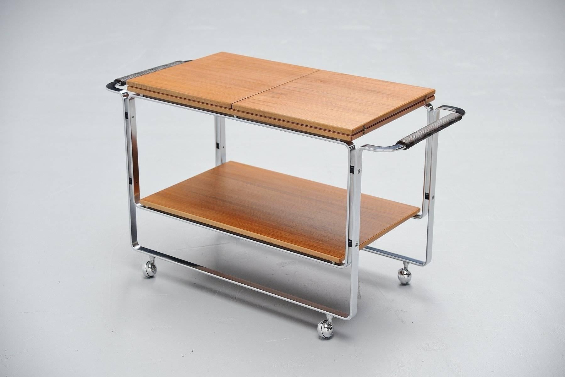 High quality serving trolley model T128 designed by Horst Brüning for Kill International, Germany, 1968. This serving cart is made of matte chrome-plated steel and it has a teak wooden folding top. This rare tea cart is very hard to find and in