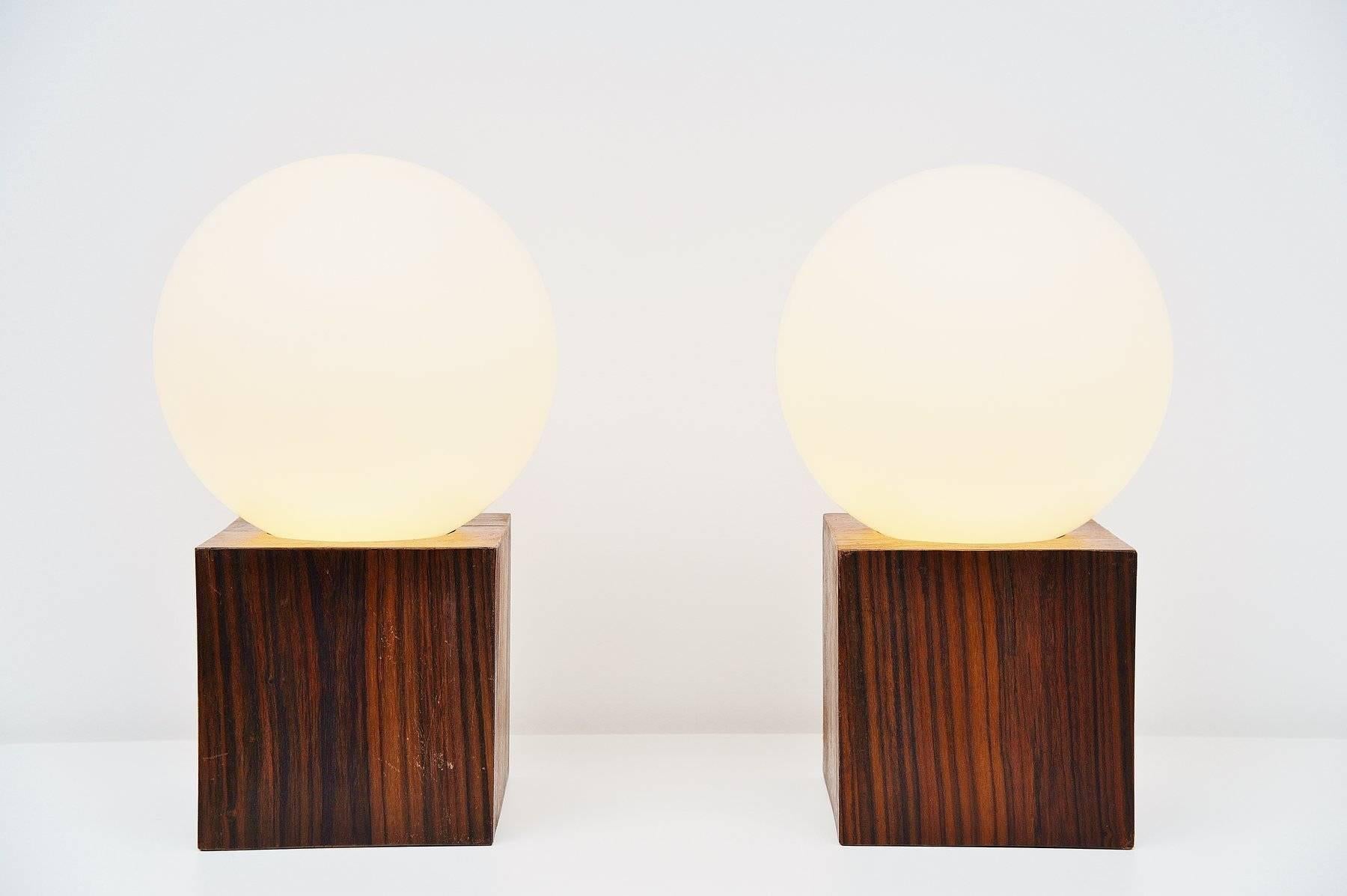 Fantastic oversized table lamps designed and made by Studio Reggiani, Italy, 1970. These table lamps have very heavy solid rosewood bases and frosted white glass shades. They give very nice warm light when lit and would look highly decorative in any