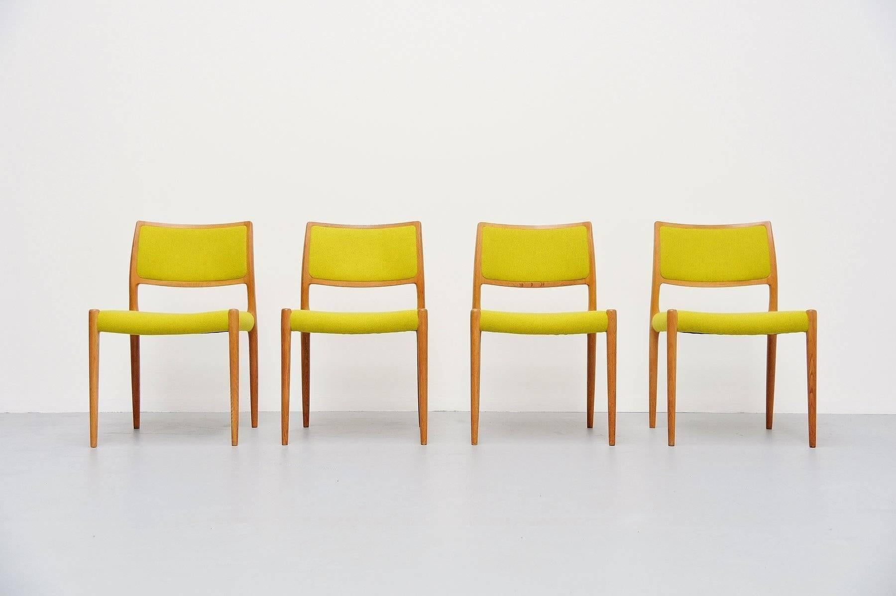 Set of four dining chairs model 80 designed by Niels Moller for J.L Møllers Møbelfabrik, Denmark 1968. These chairs are made of solid oak which is in excellent original condition and they are newly upholstered in lime green Divina fabric by