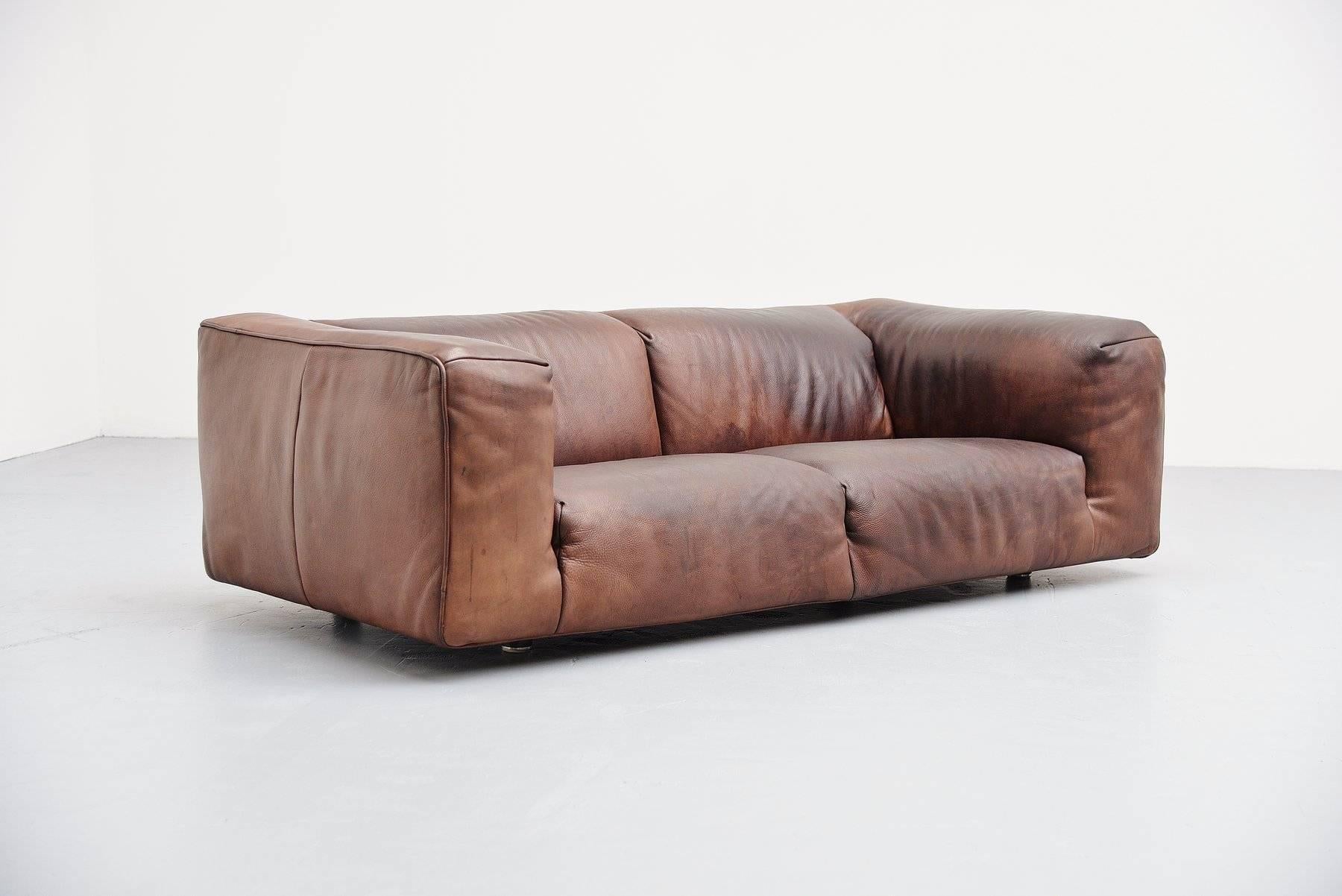 Very nice low lounge sofa designed by Gerard van den Berg for Montis, Holland, 1970. This quality leather sofa is made of dark brown buffalo leather and preserves a very nice patina from age and usage. It has a nice shape and seats very comfortable.